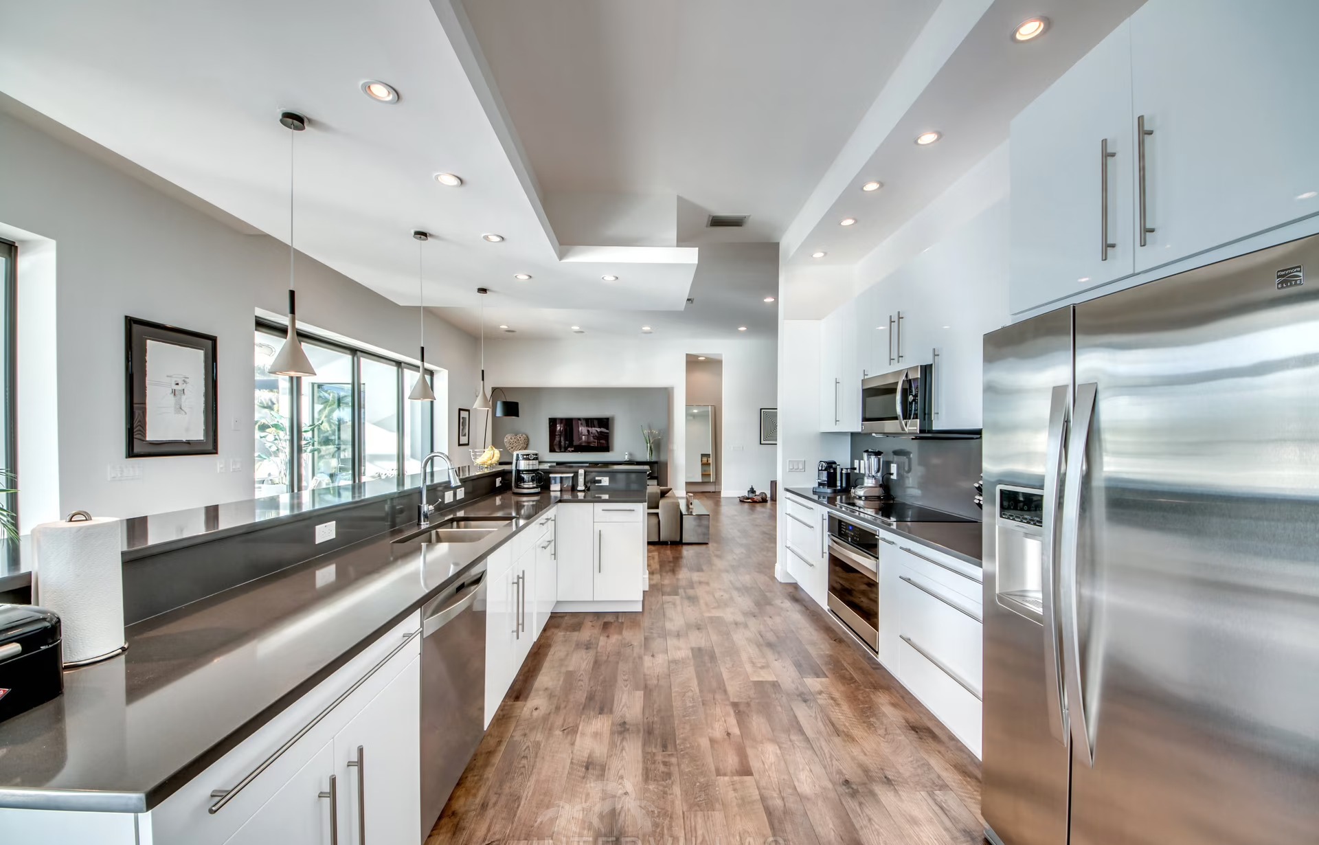 Infinity-Salzwasserpool mit Sonnenliegen und Blick auf den Kanal.