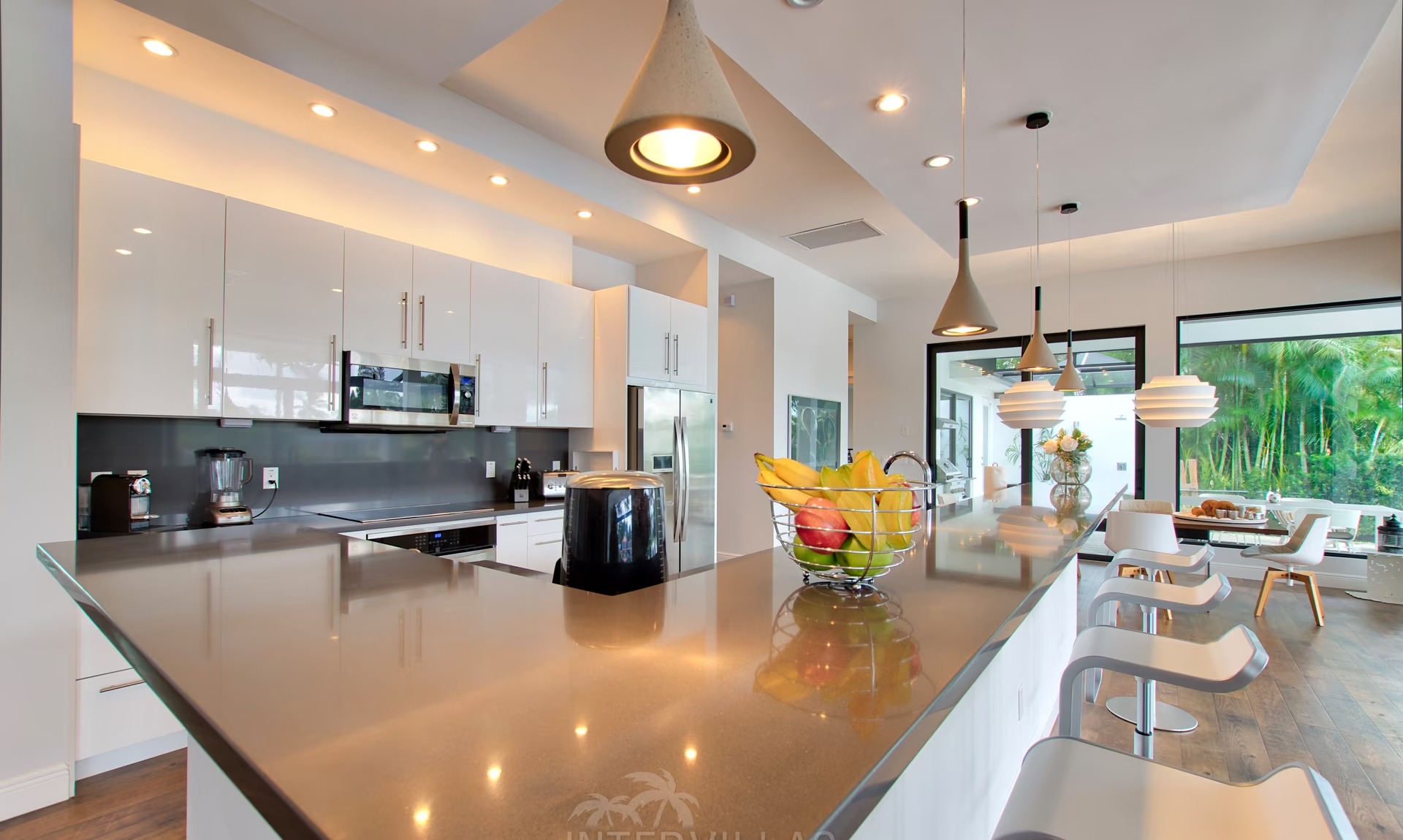 Infinity-Salzwasserpool mit Liegen und Blick auf den Kanal bei Sonnenuntergang.