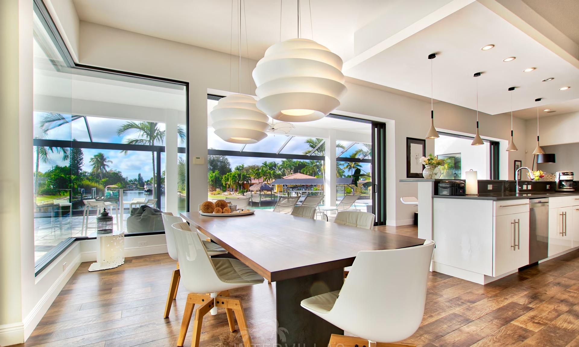 Infinity-Salzwasserpool am Wasser mit Sonnenliegen und Blick auf den Sonnenuntergang.