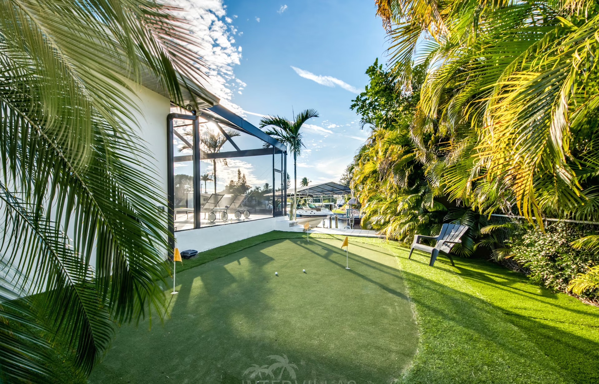 Infinity-Salzwasserpool mit Sonnenliegen und Blick auf den Kanal bei Sonnenuntergang.
