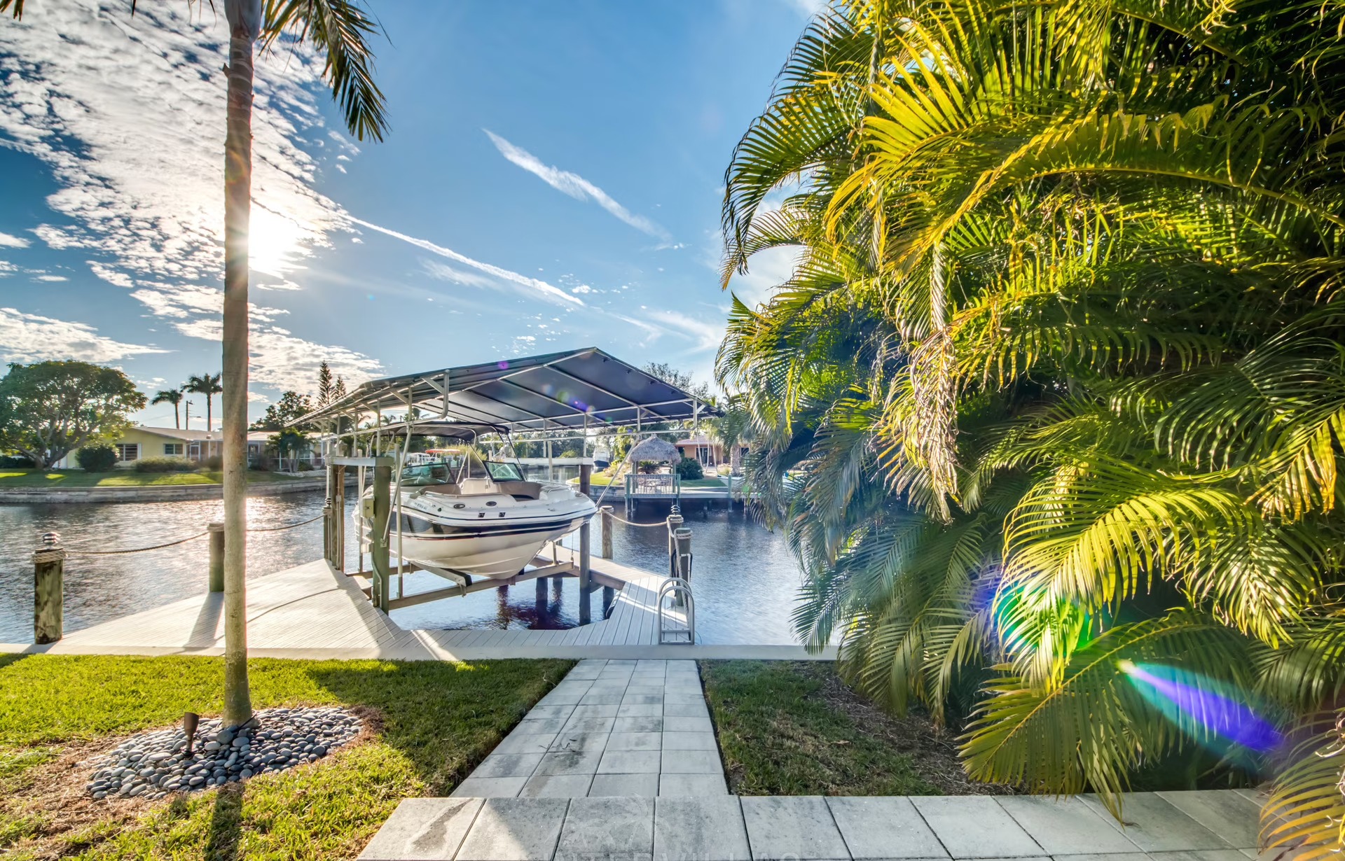 Infinity-Salzwasserpool am Wasser mit Liegen und Blick auf den Sonnenuntergang.