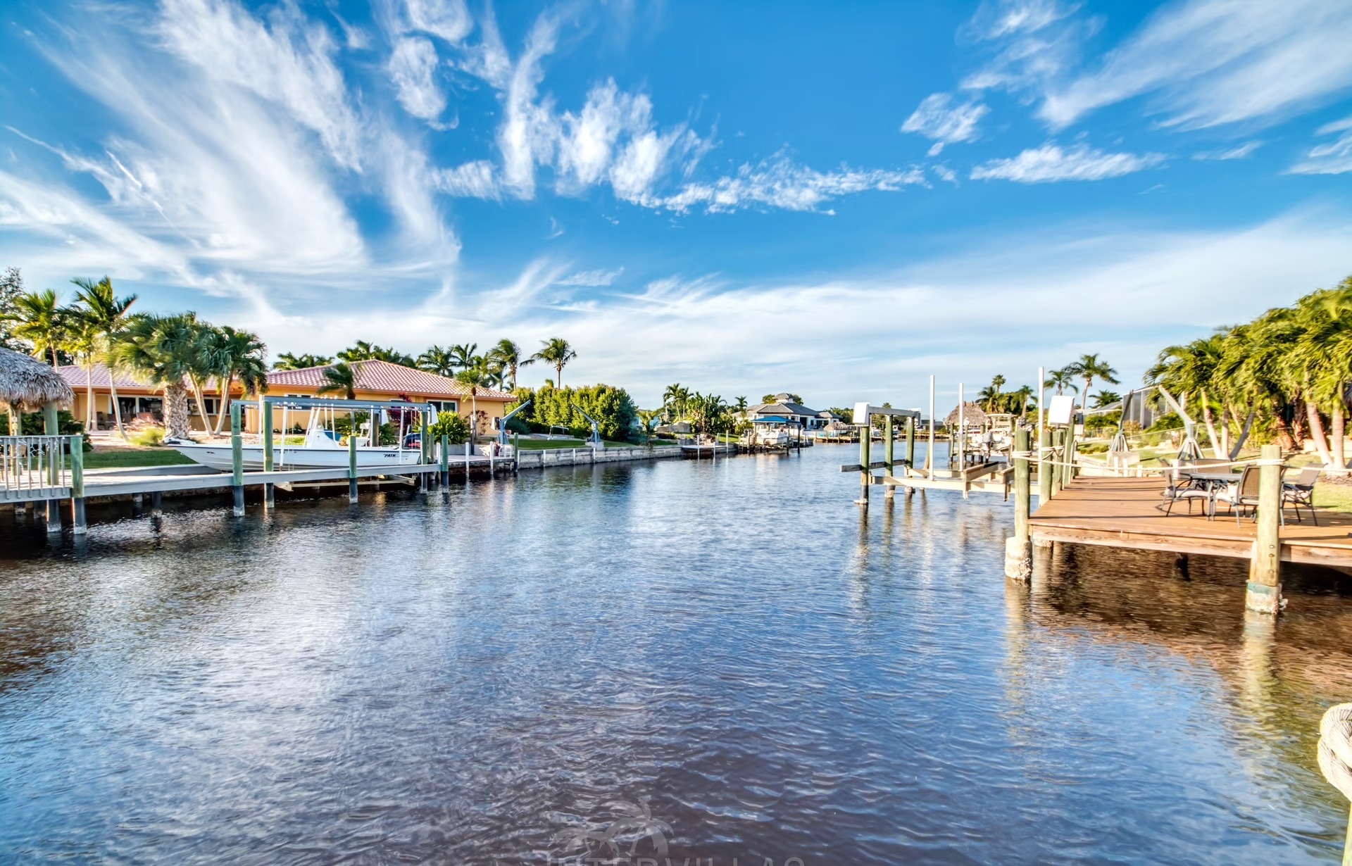 Infinity-Salzwasserpool am Wasser mit Sonnenliegen und Blick auf den Sonnenuntergang.