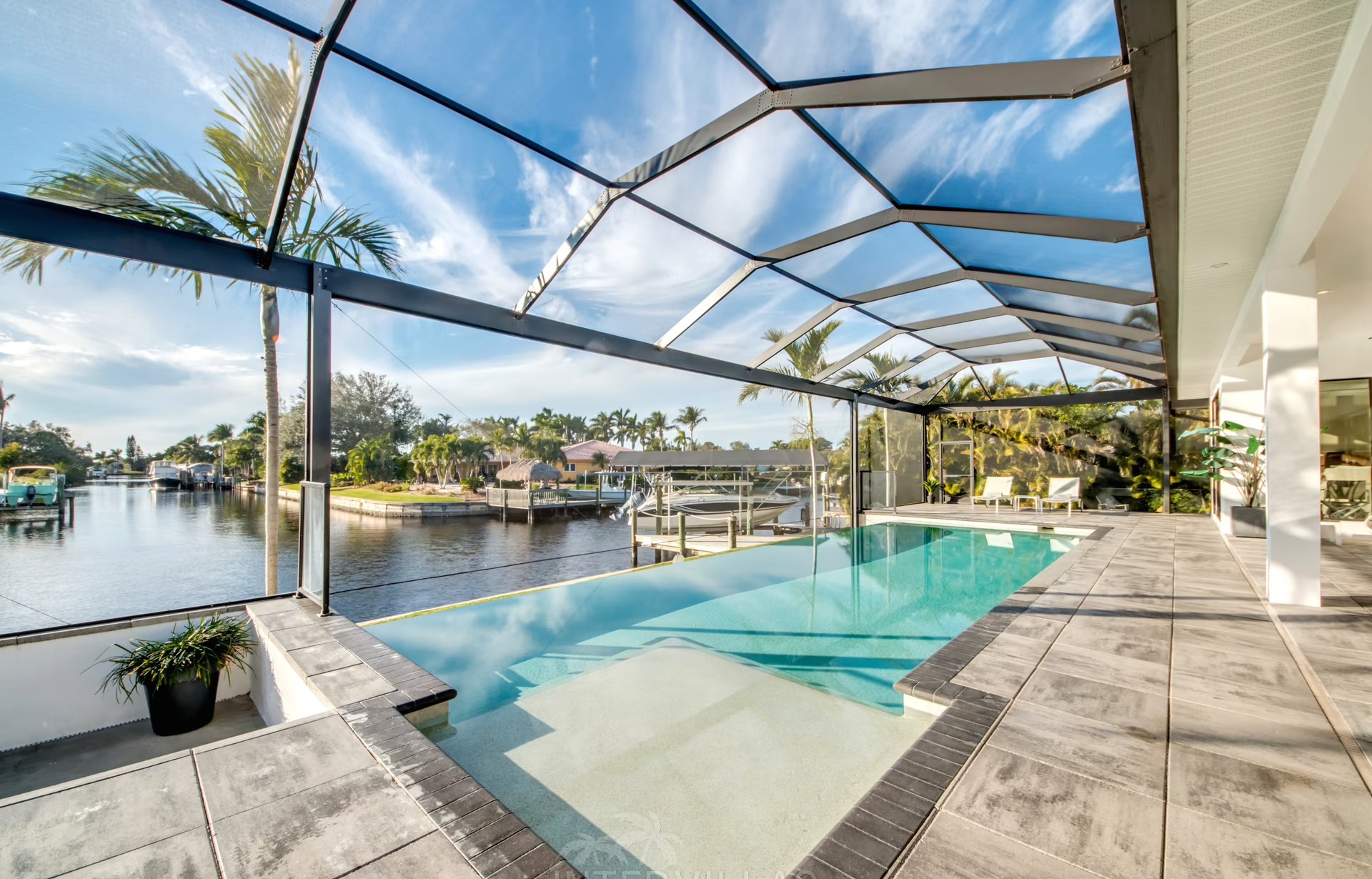 Infinity-Salzwasserpool mit Blick auf den Kanal und Sonnenuntergang.