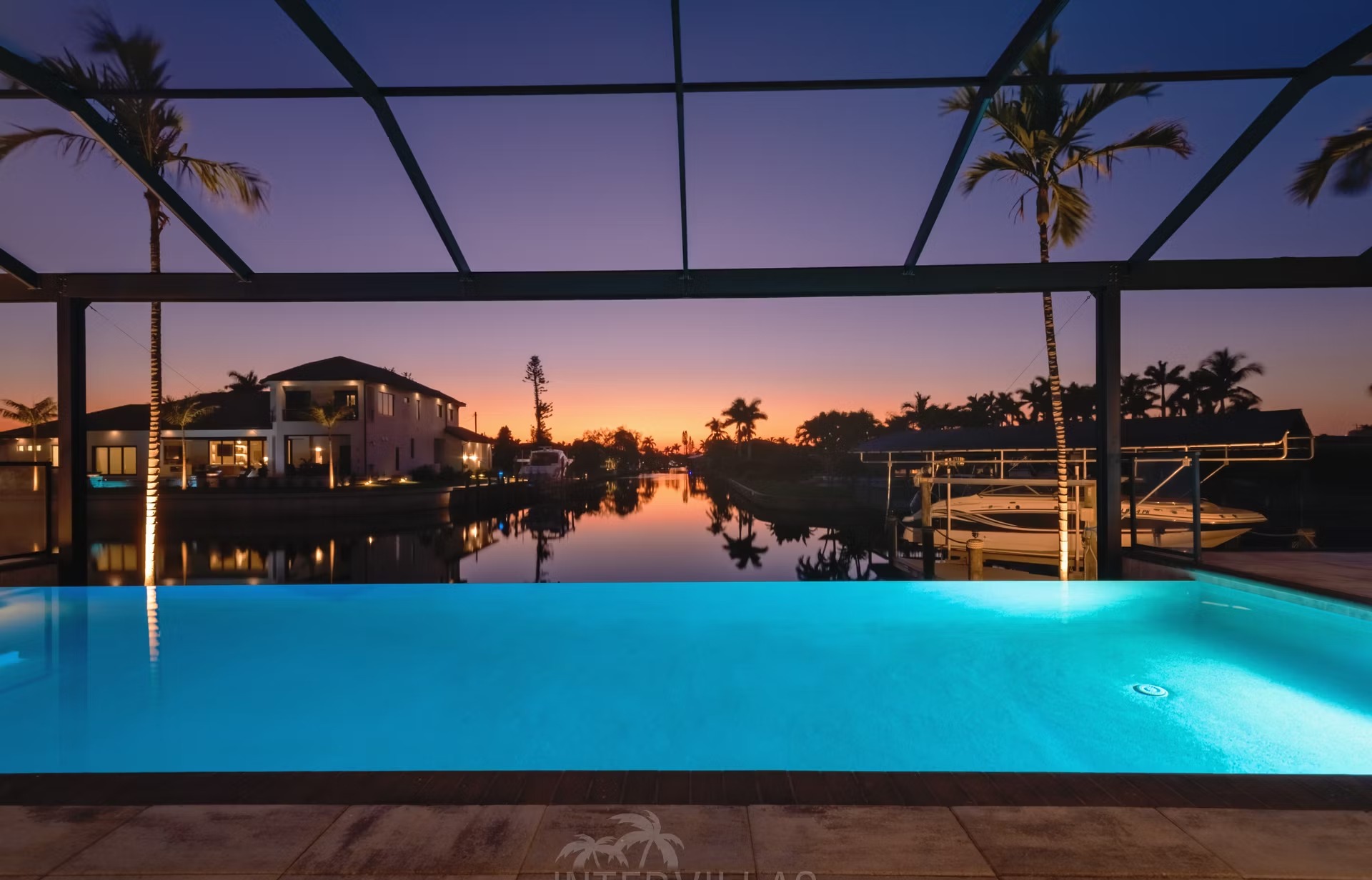 Infinity-Salzwasserpool mit Liegen und Blick aufs Wasser bei Sonnenuntergang.
