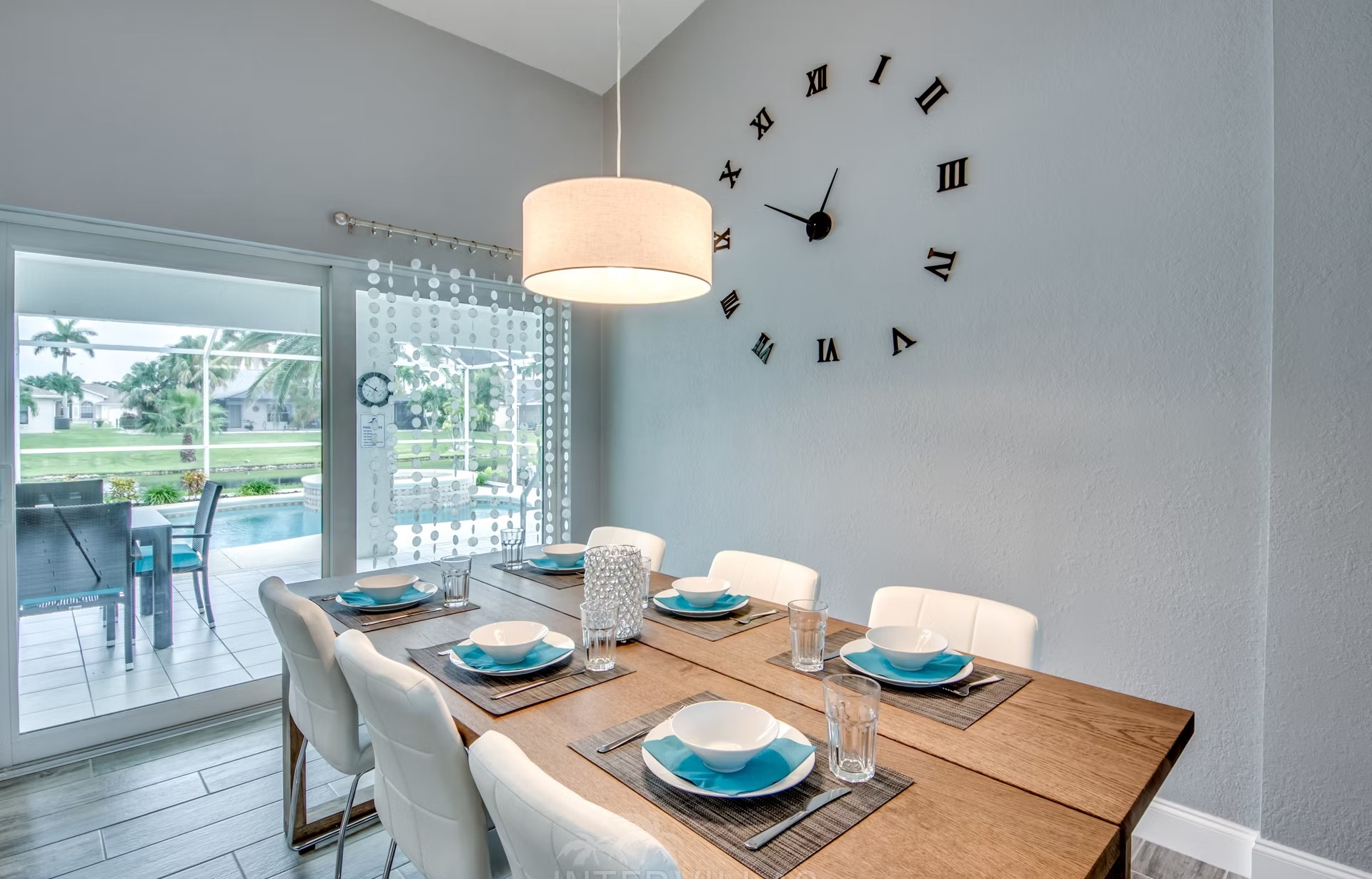 Überdachter Außenbereich mit Sitzgruppe und Blick auf Pool und Whirlpool.