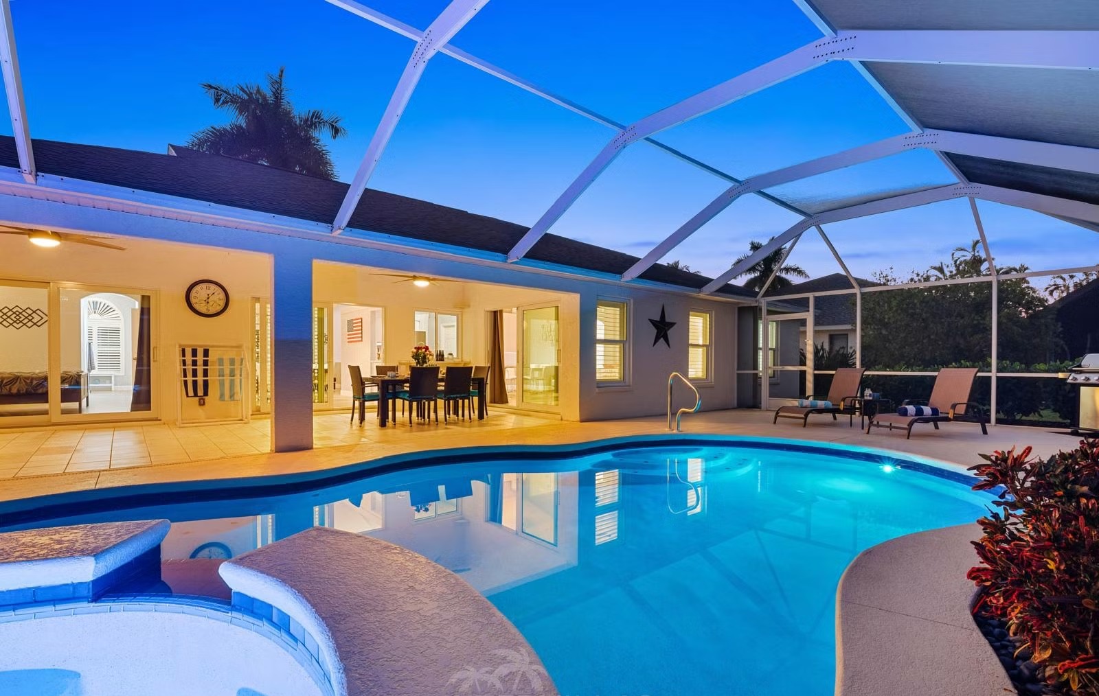 Überdachter Terrassenbereich mit Sitzmöbeln und Blick auf Pool und Whirlpool.