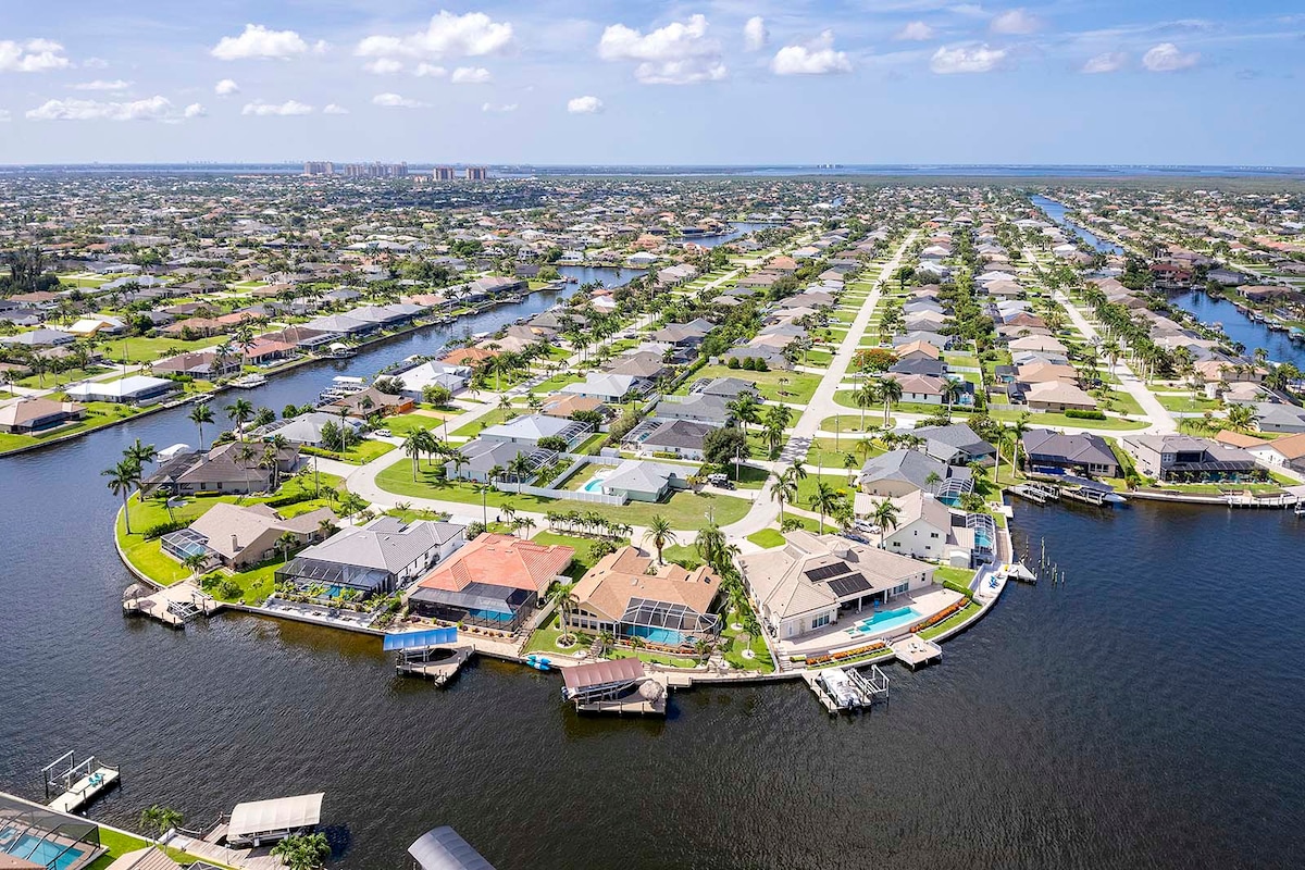 Sonnenuntergang über dem Kanal vom Poolbereich mit Lanai und Bootsanleger.