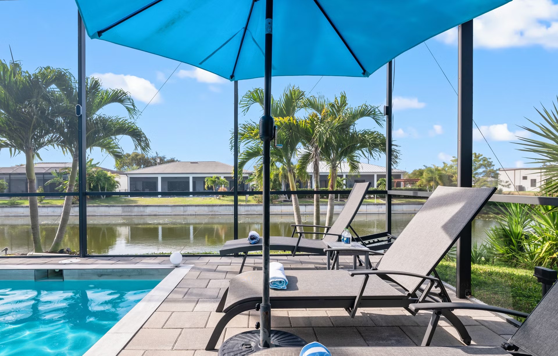 Salzwasserpool mit Liegen auf der Lanai und Blick auf den Kanal.