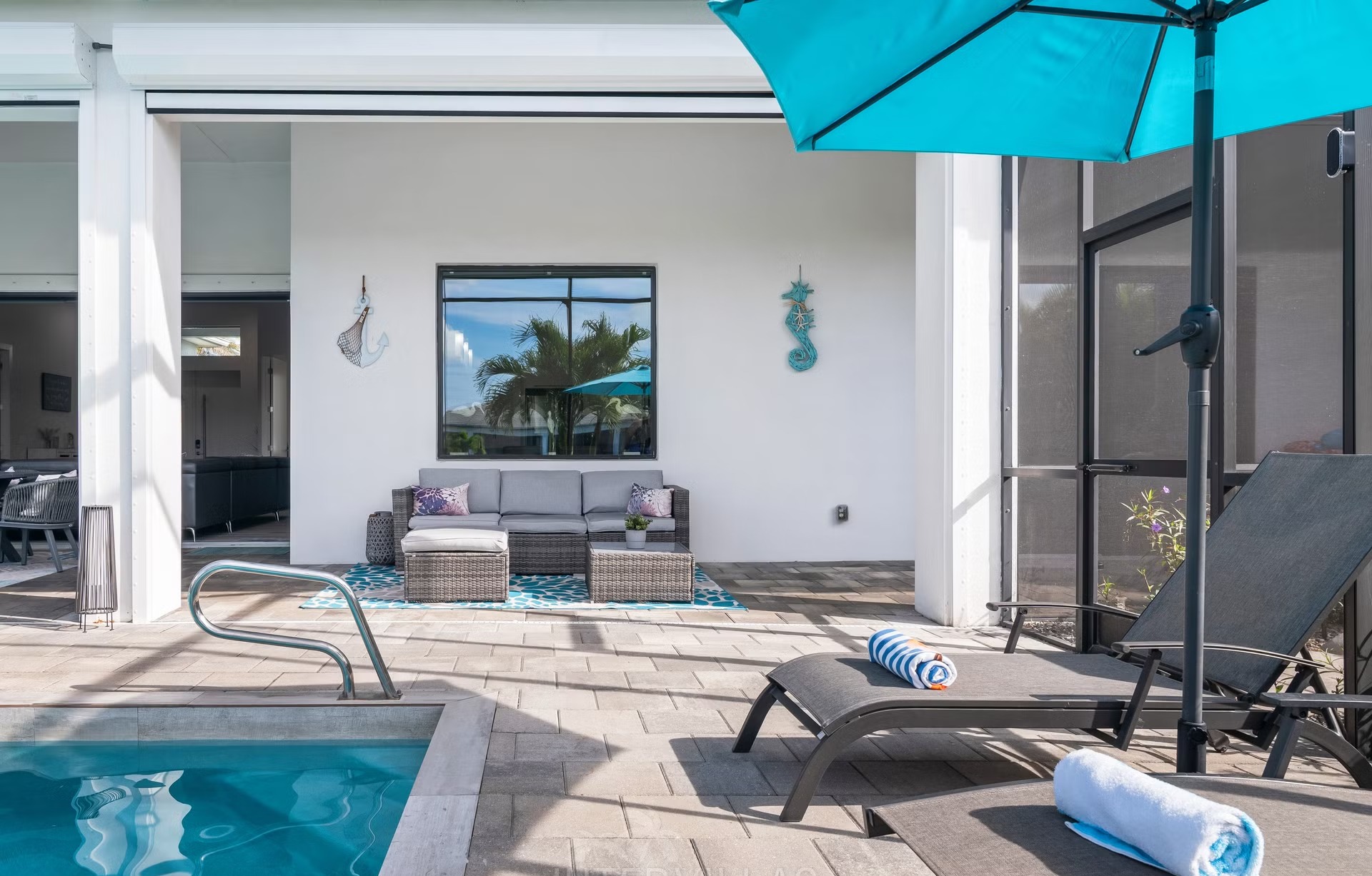 Poolbereich mit Salzwasserpool, Outdoorküche und Blick auf den Kanal