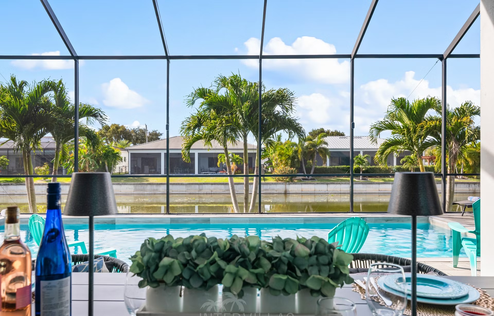 Außenbereich mit Salzwasserpool, Liegen und Outdoorküche am Kanal.