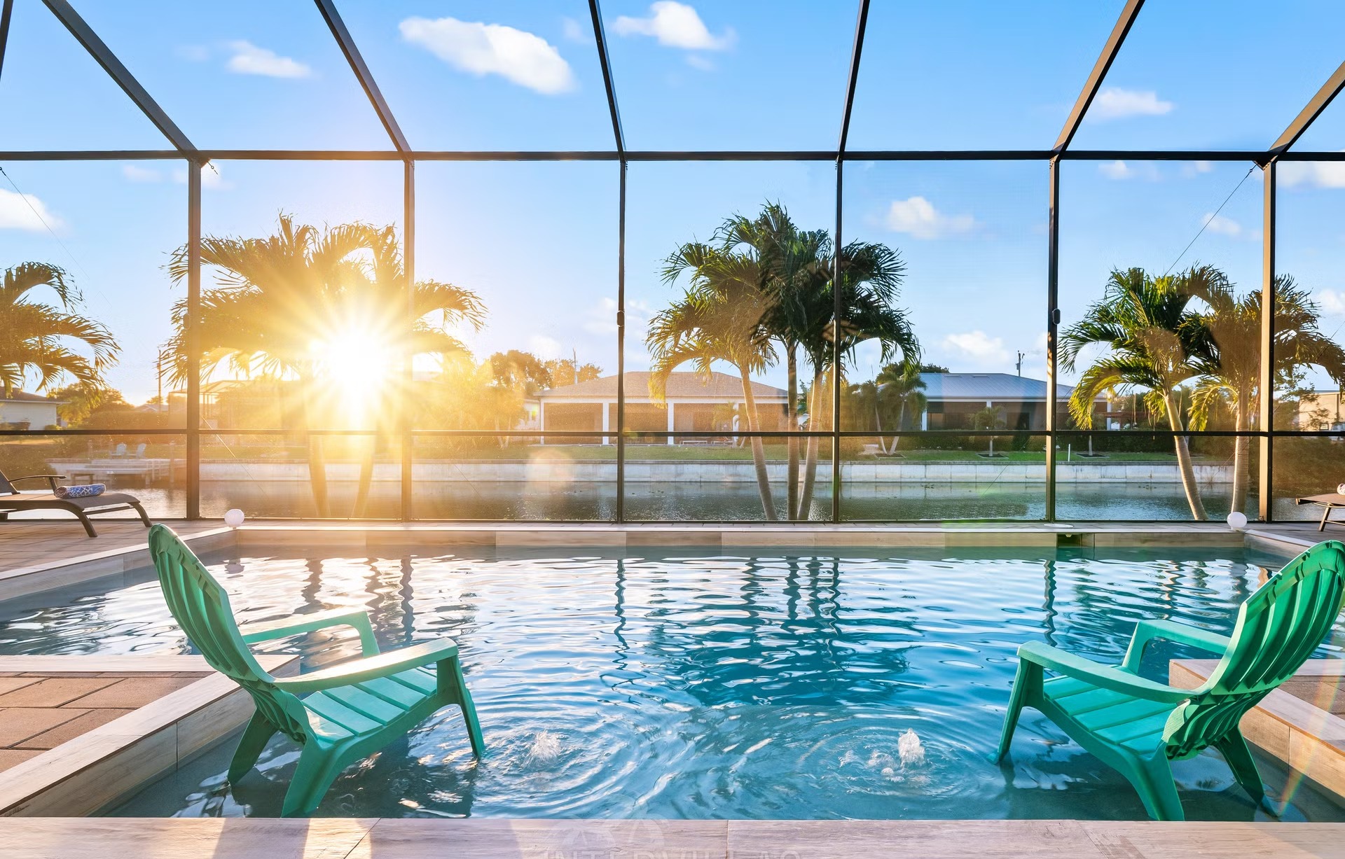 Poolbereich mit Salzwasserpool, Outdoorküche und Blick auf den Kanal.