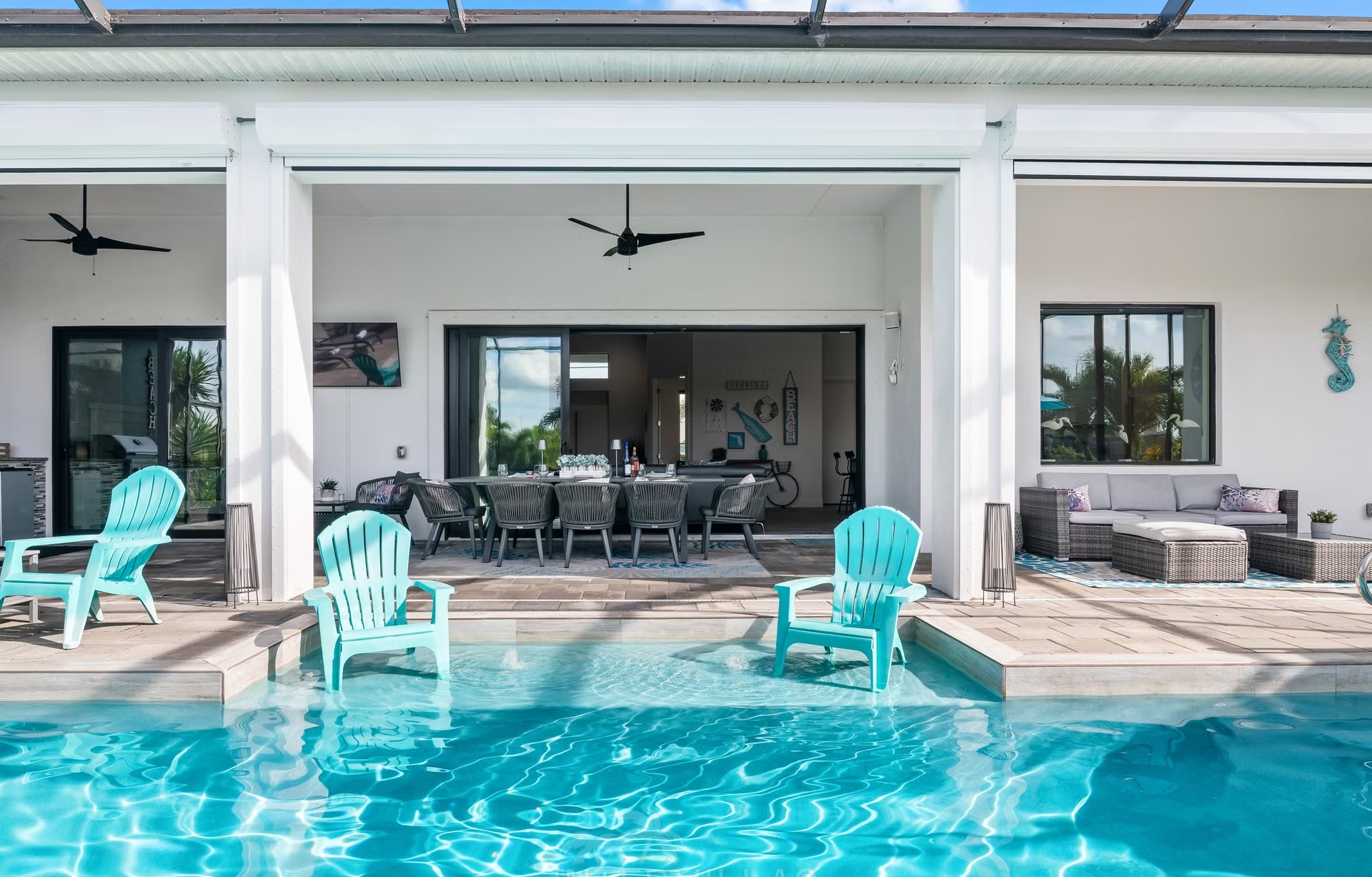 Poolbereich mit Salzwasserpool, Outdoorküche und Blick auf den Kanal.