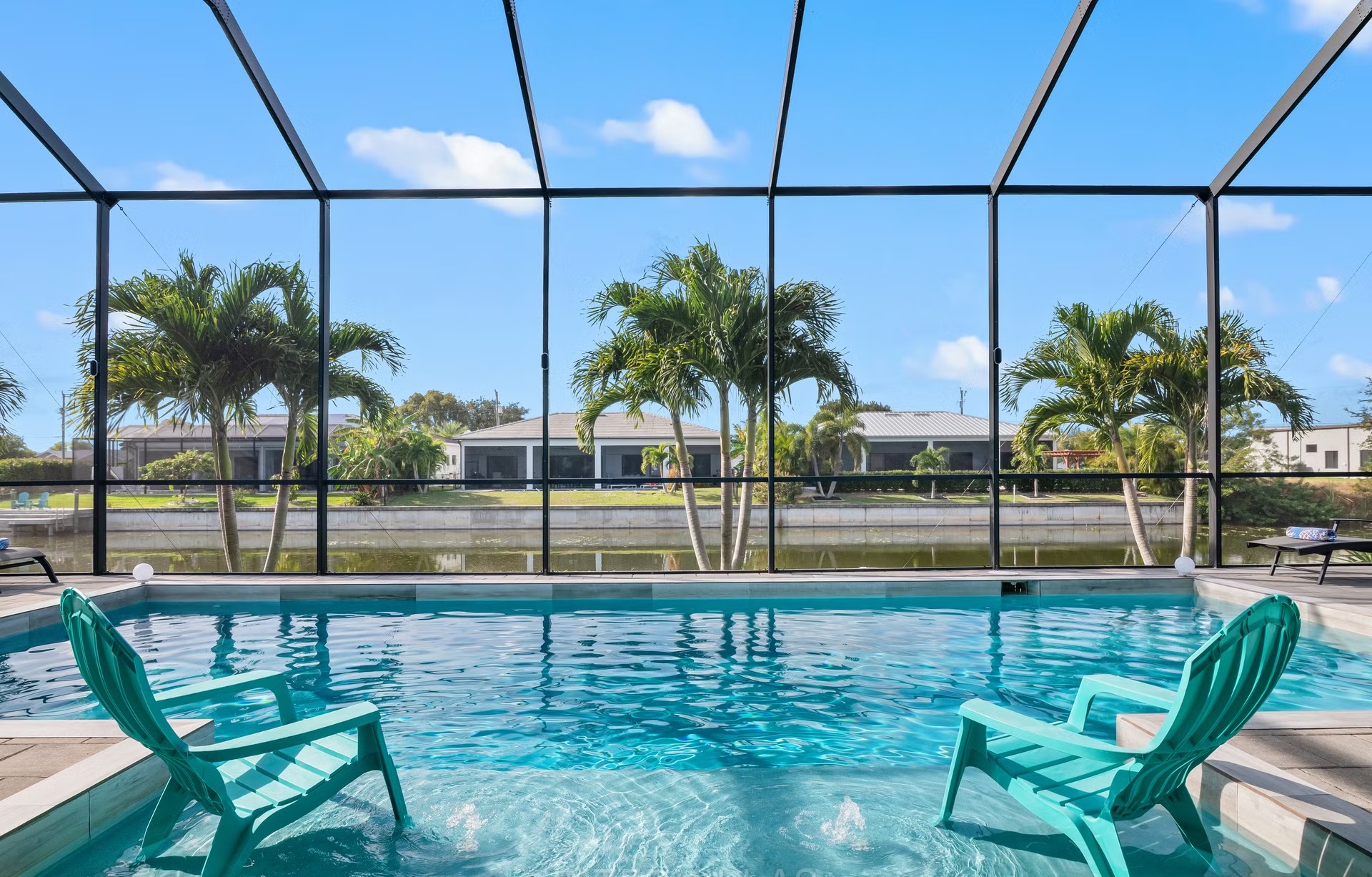 Poolbereich mit Salzwasserpool, Outdoorküche und Blick auf den Kanal.