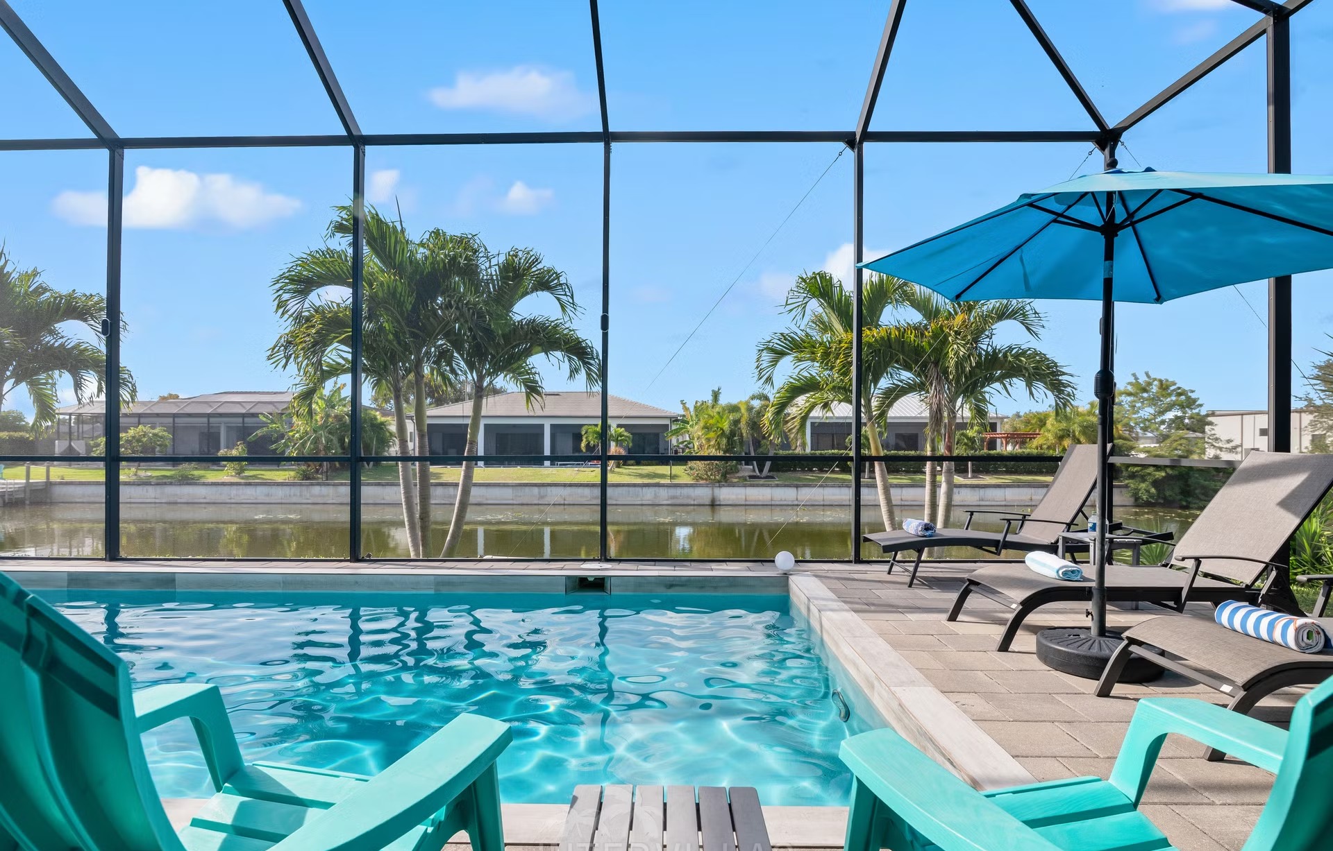 Poolbereich auf der Lanai mit Salzwasserpool, Outdoorküche und Blick auf den Kanal.