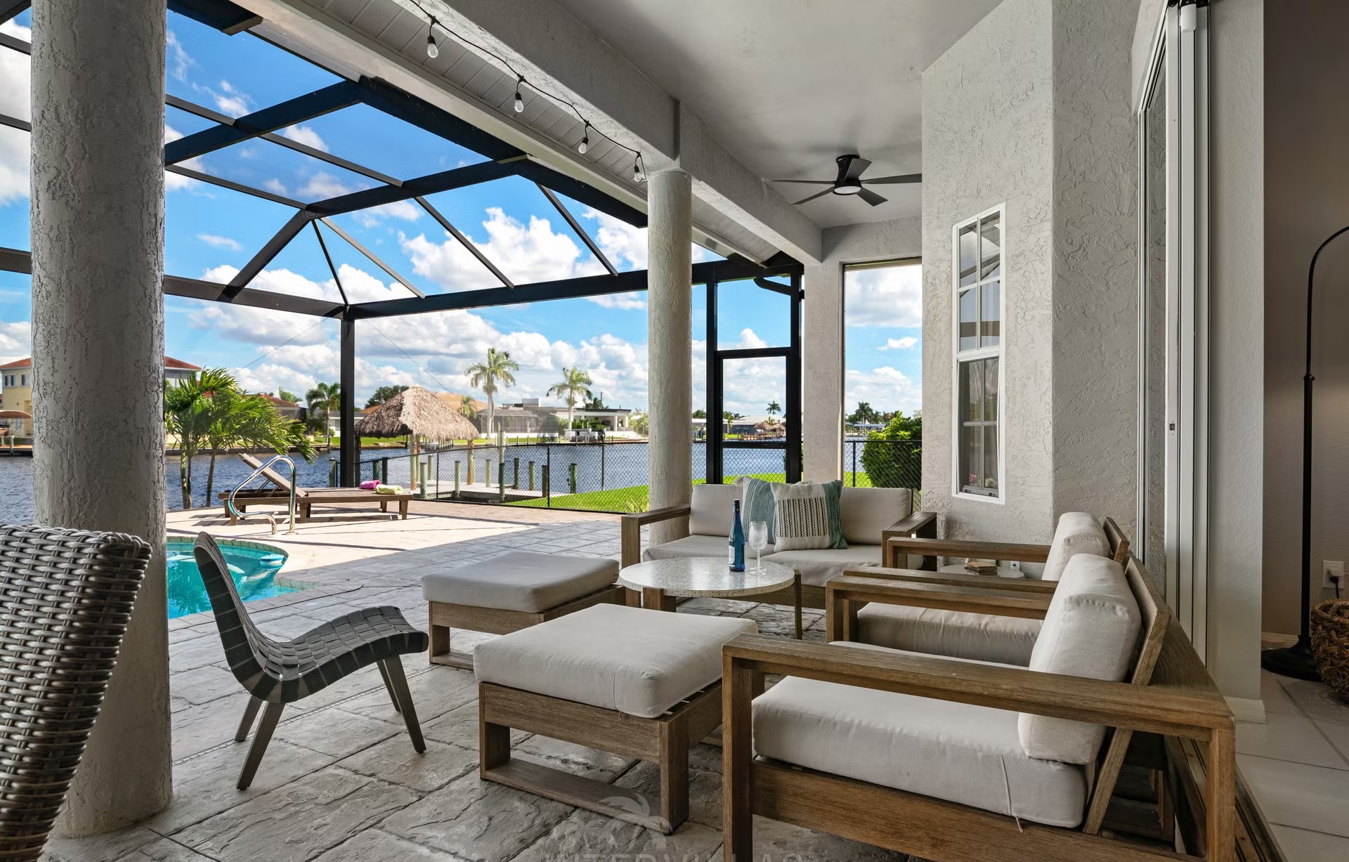 Poolbereich mit Outdoorküche und Blick auf den Kanal.