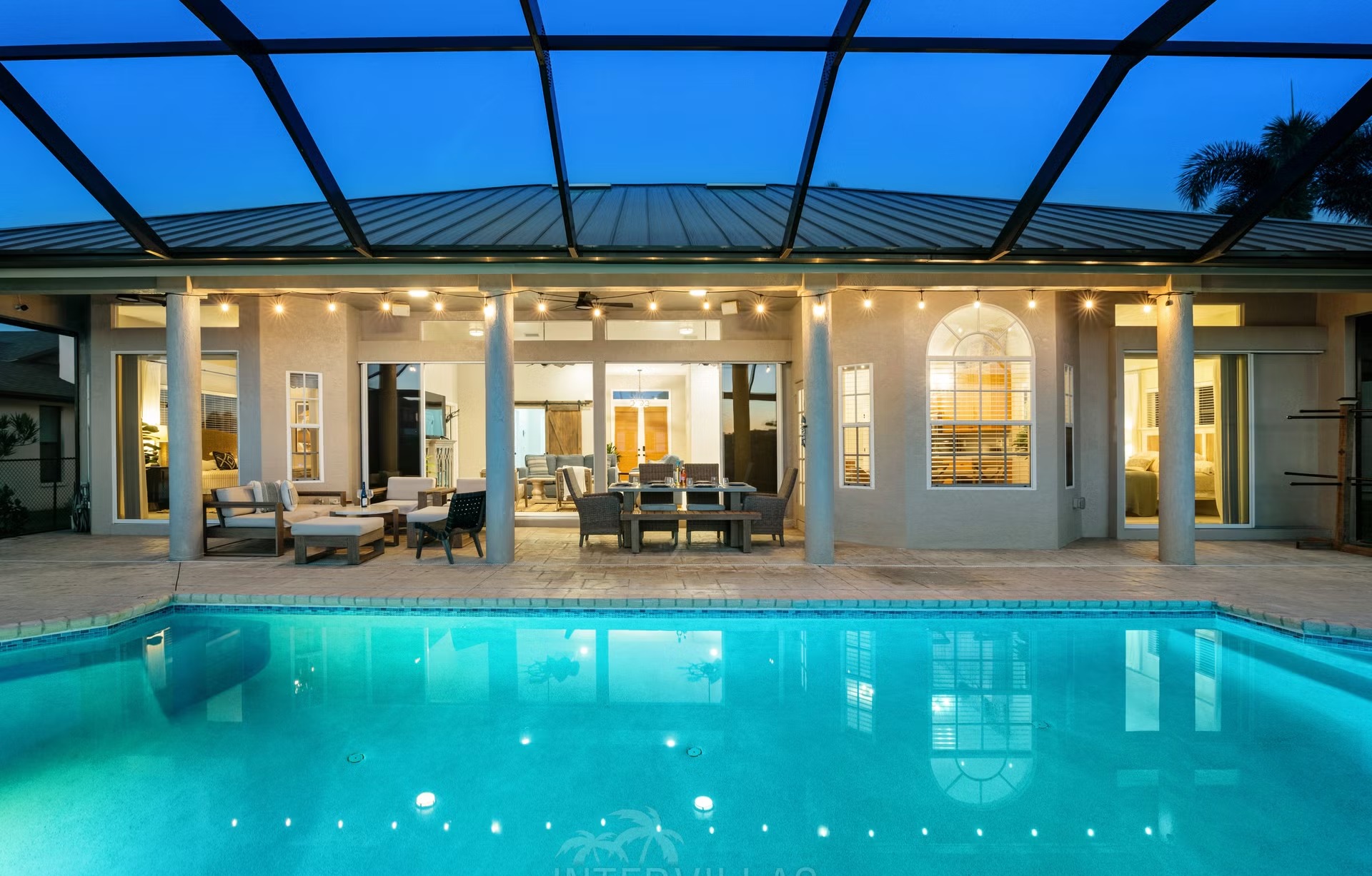 Poolbereich mit Outdoorküche und Blick auf den Kanal.