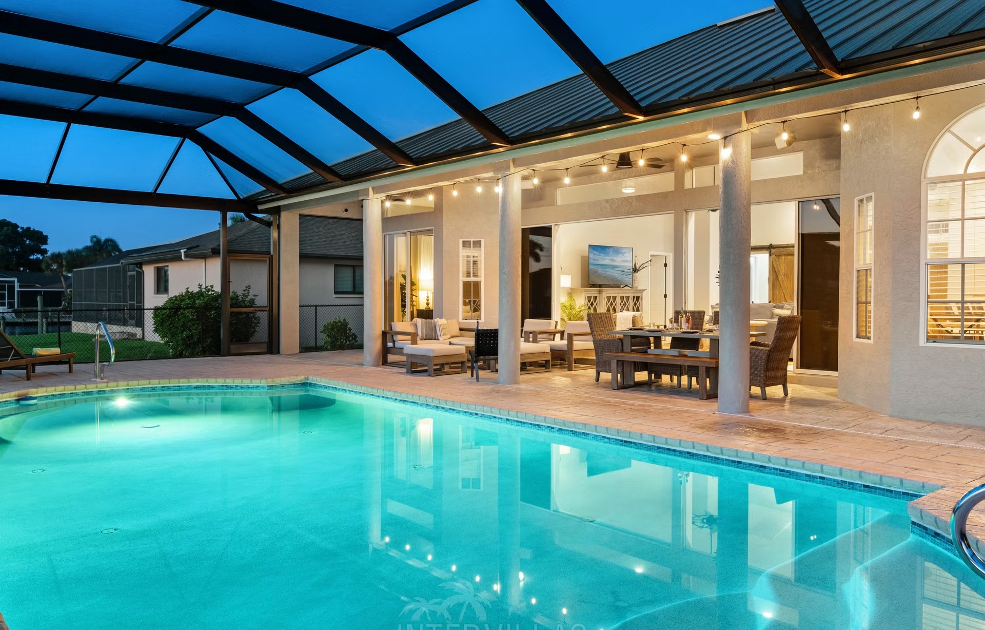 Poolbereich mit Outdoorküche und Blick auf den Kanal.