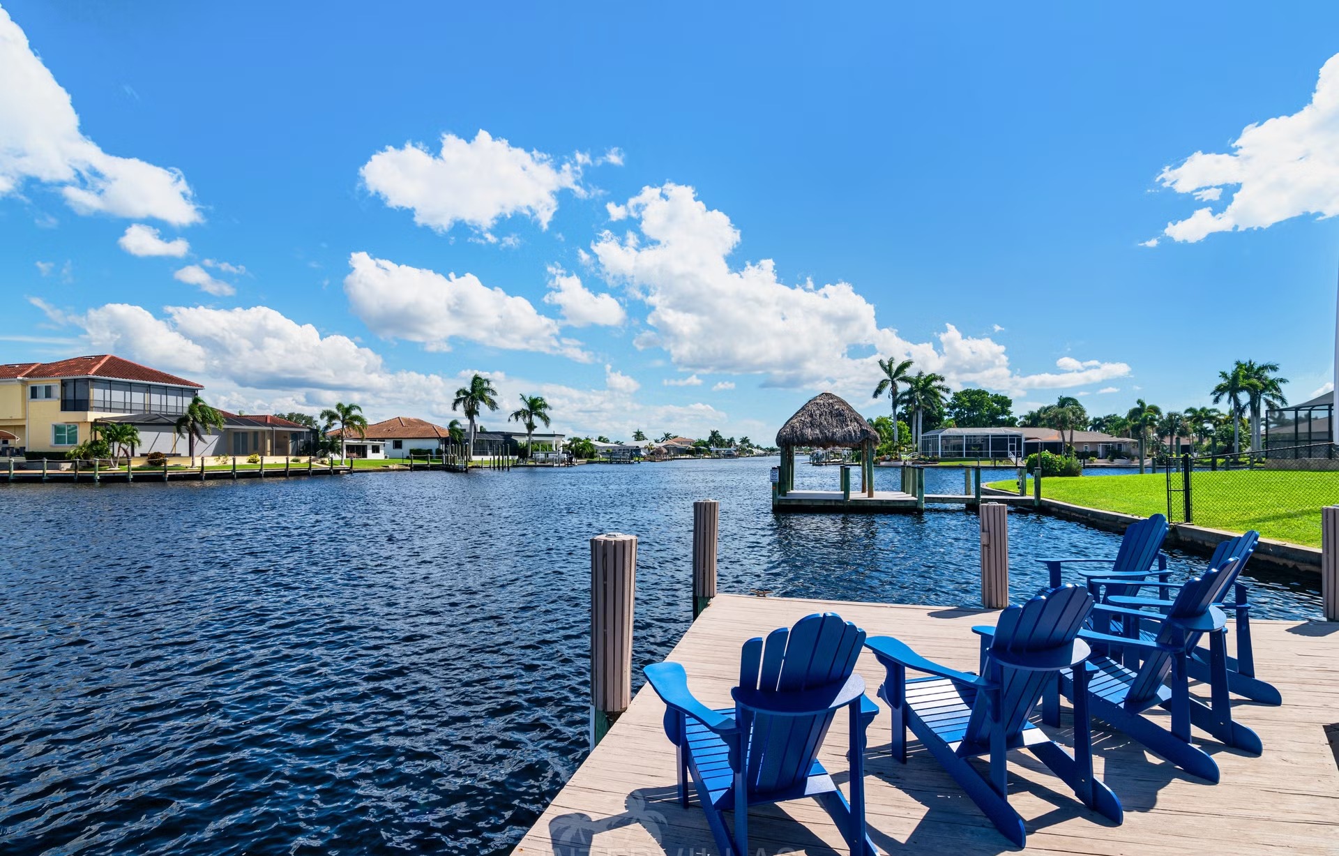 Poolbereich mit Outdoorküche und Blick auf den Kanal.