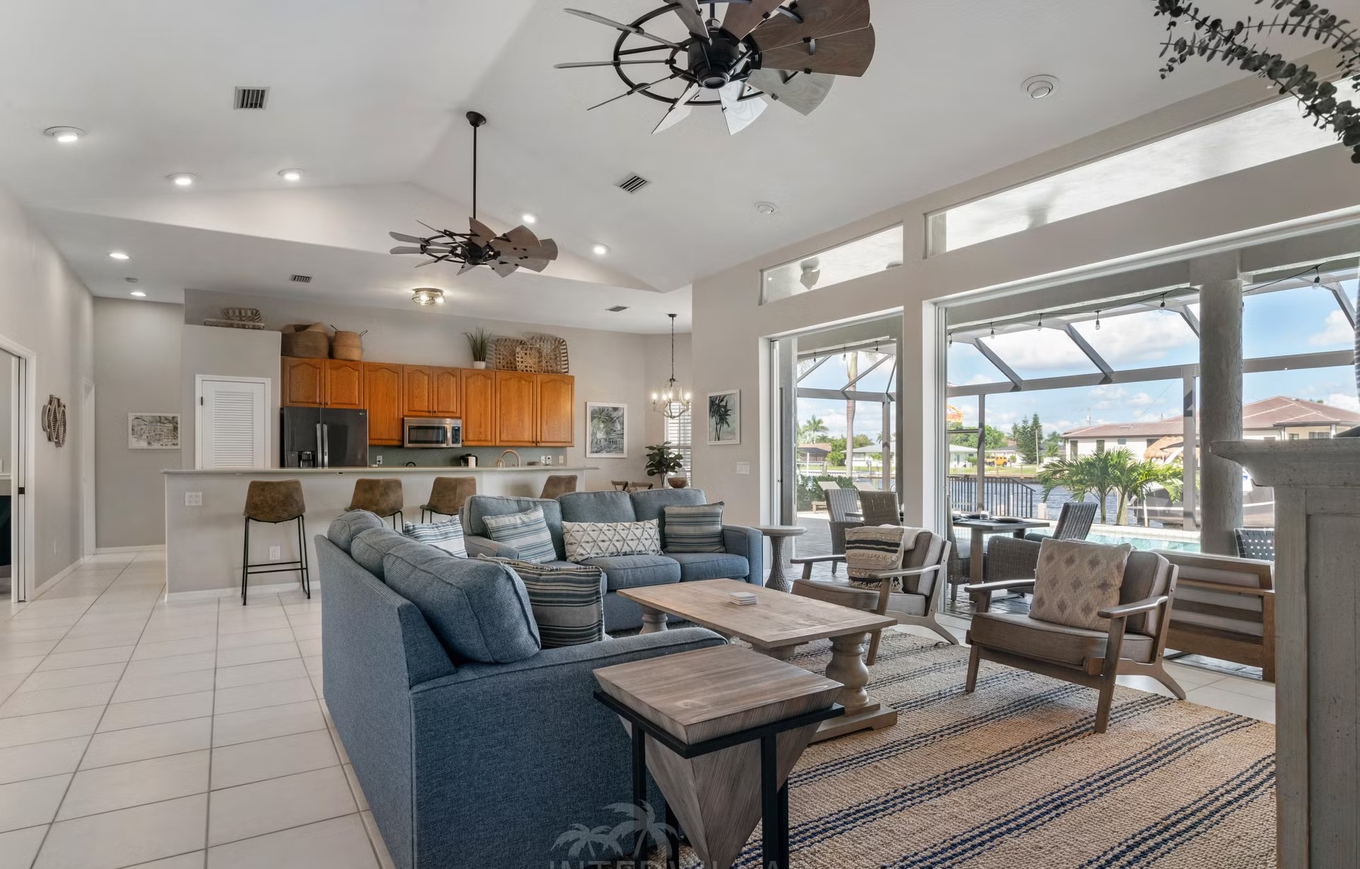 Poolbereich mit Outdoorküche und Blick auf den Kanal.