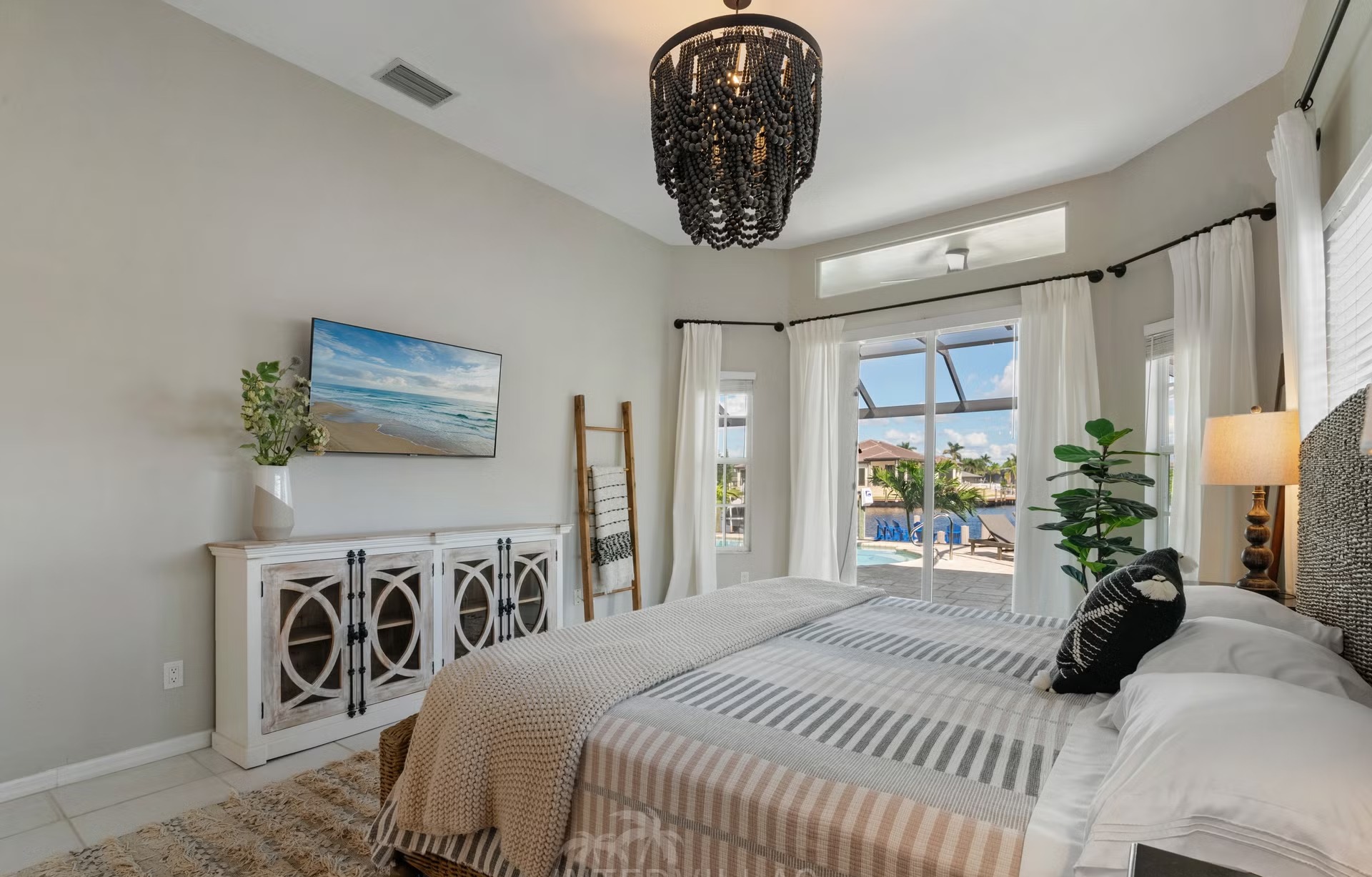 Poolbereich mit Outdoorküche und Blick auf den Kanal.