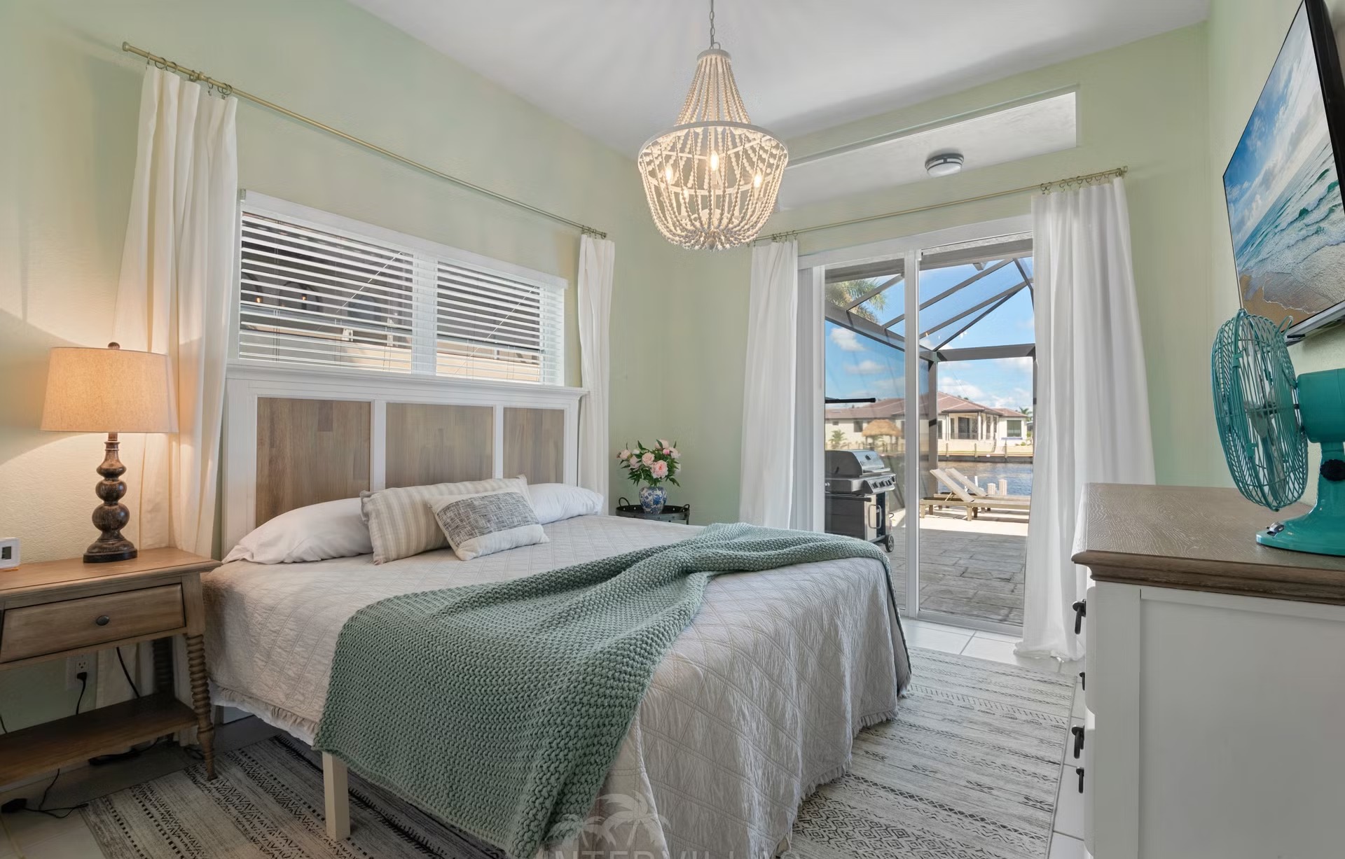 Poolbereich mit Outdoorküche und Blick auf den Kanal.