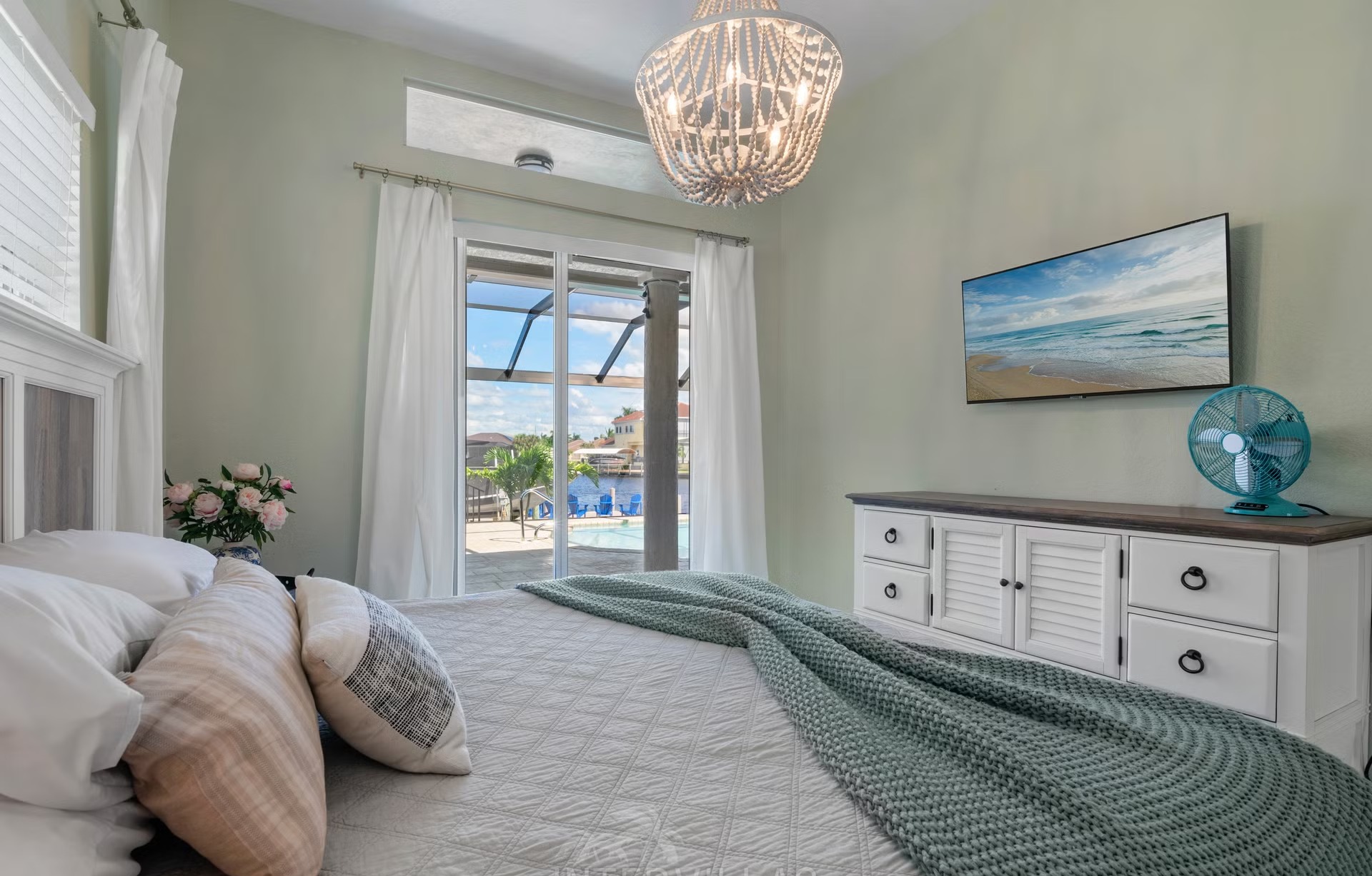 Poolbereich mit Outdoorküche und Blick auf den Kanal.