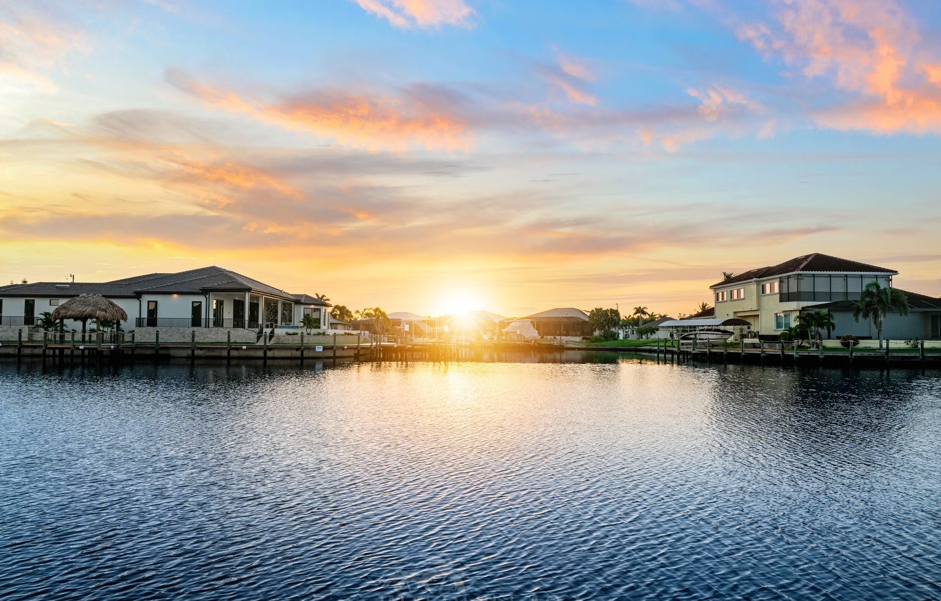 Poolbereich mit Outdoorküche und Blick auf den Kanal.