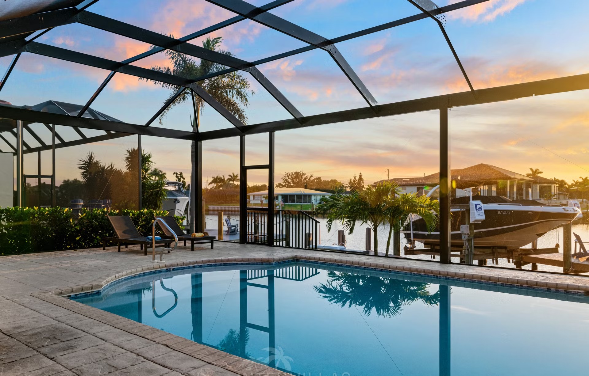 Poolbereich mit Outdoorküche und Blick auf den Kanal.
