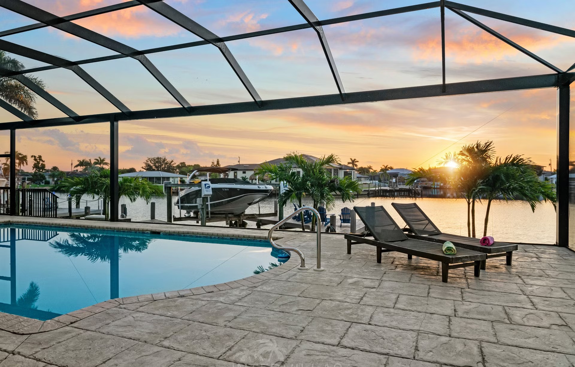 Poolbereich mit Outdoorküche und Blick auf den Kanal.