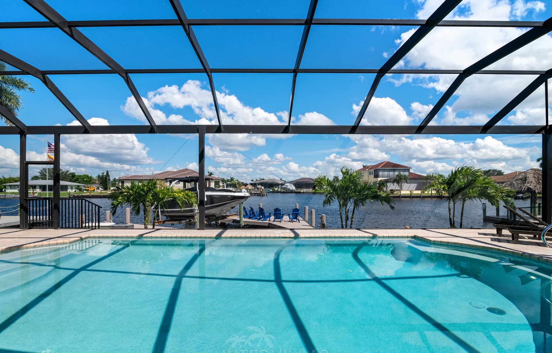 Poolbereich mit Outdoorküche und Blick auf den Kanal.