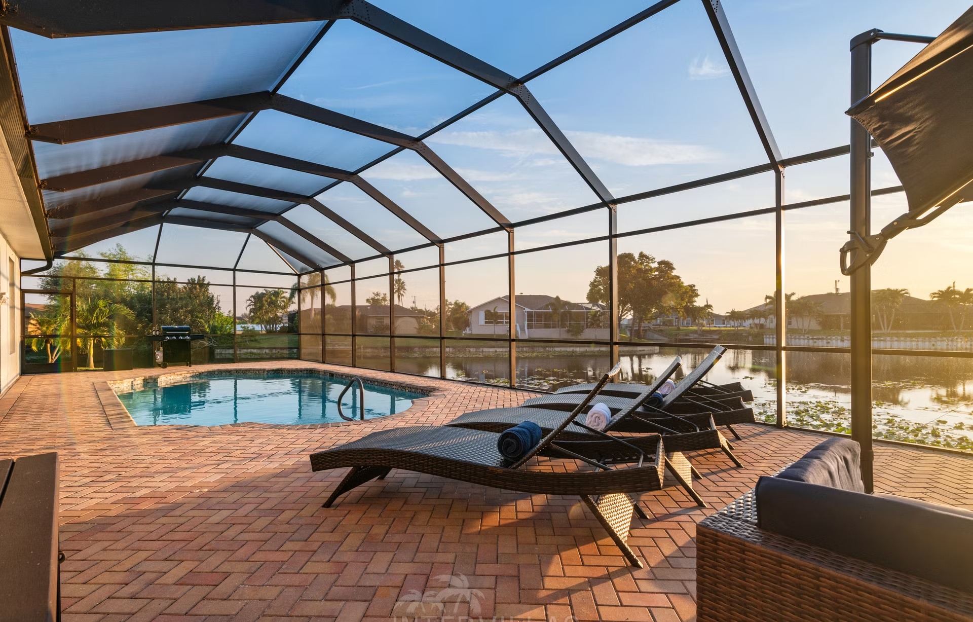 Beheizter Pool mit Liegen und Outdoor-Küche am Kanal.