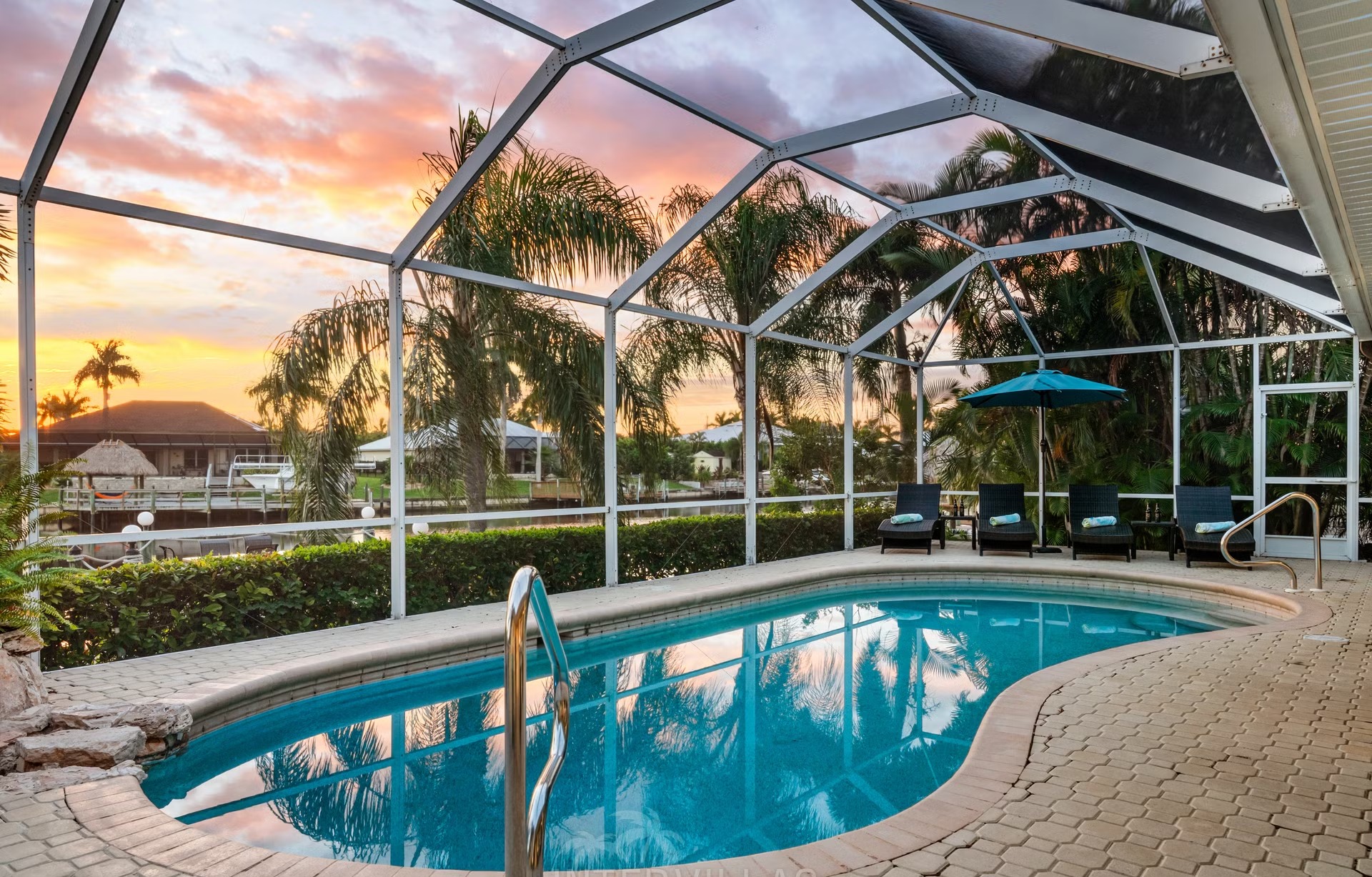 Poolbereich mit Liegen und Blick auf den Kanal am eigenen Dock