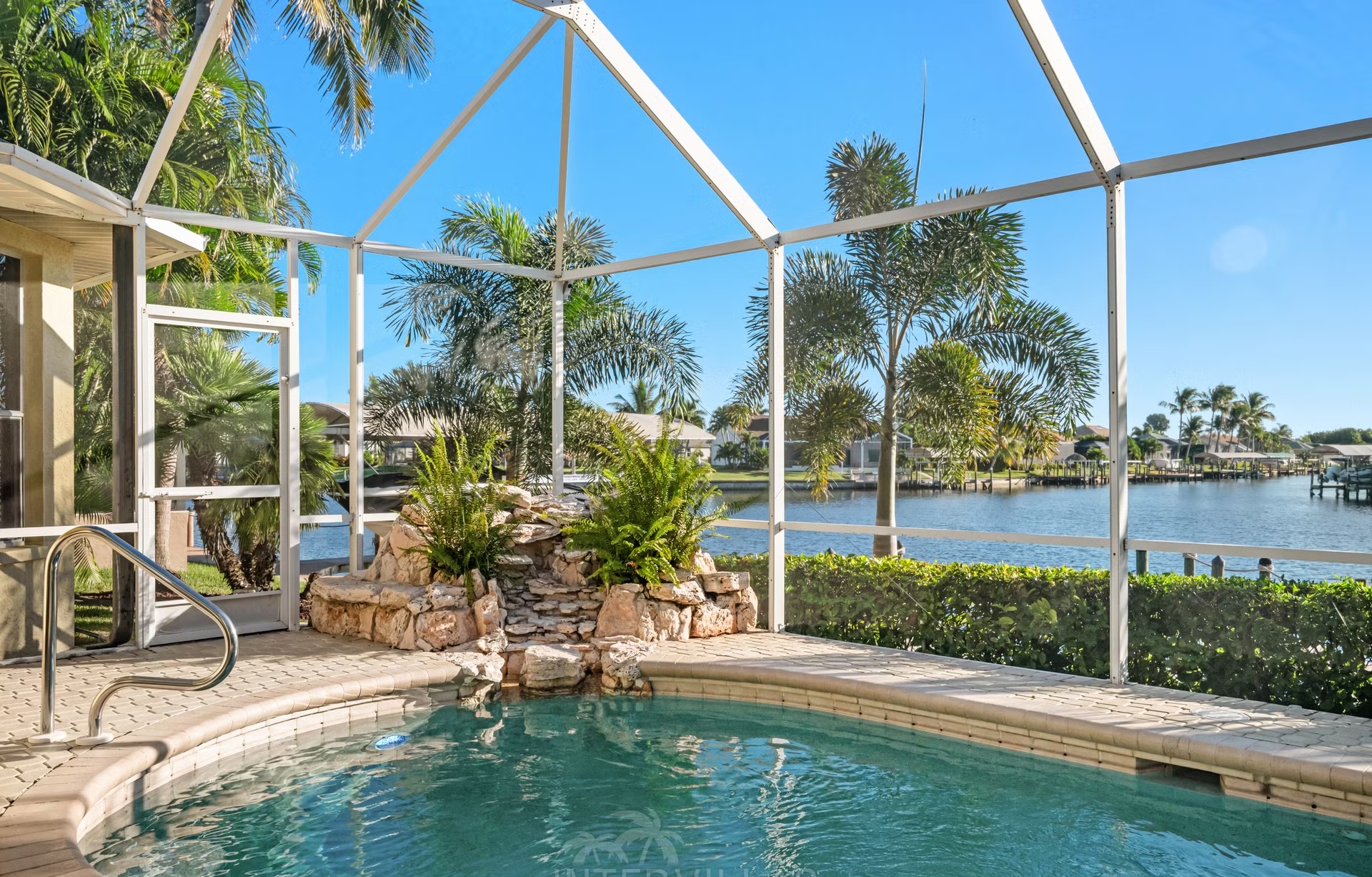 Poolbereich mit Liegen und überdachtem Sitzplatz am Kanal mit Bootssteg und Kajaks.