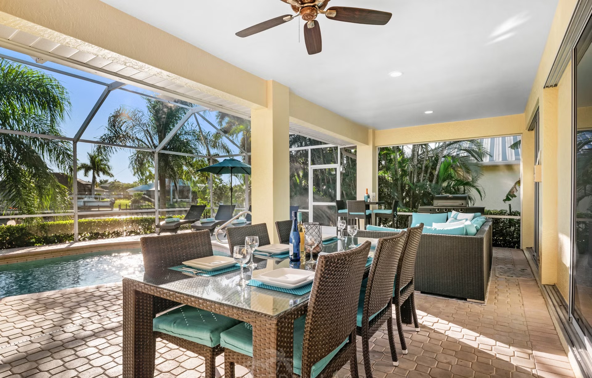 Poolbereich mit Liegen und überdachtem Sitzplatz am Kanal mit Bootsanlegestelle und Kajaks.