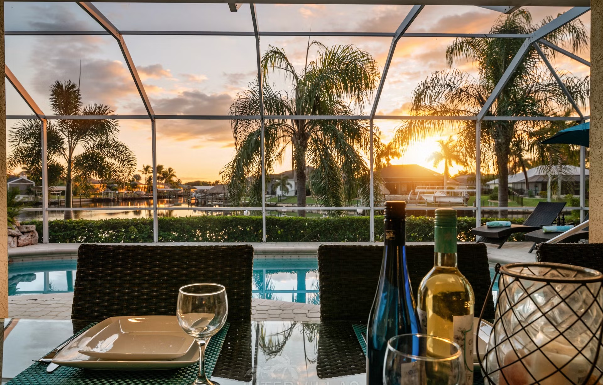 Poolbereich mit Liegen und überdachtem Sitzplatz am Kanal mit Bootsdock und Kajaks.