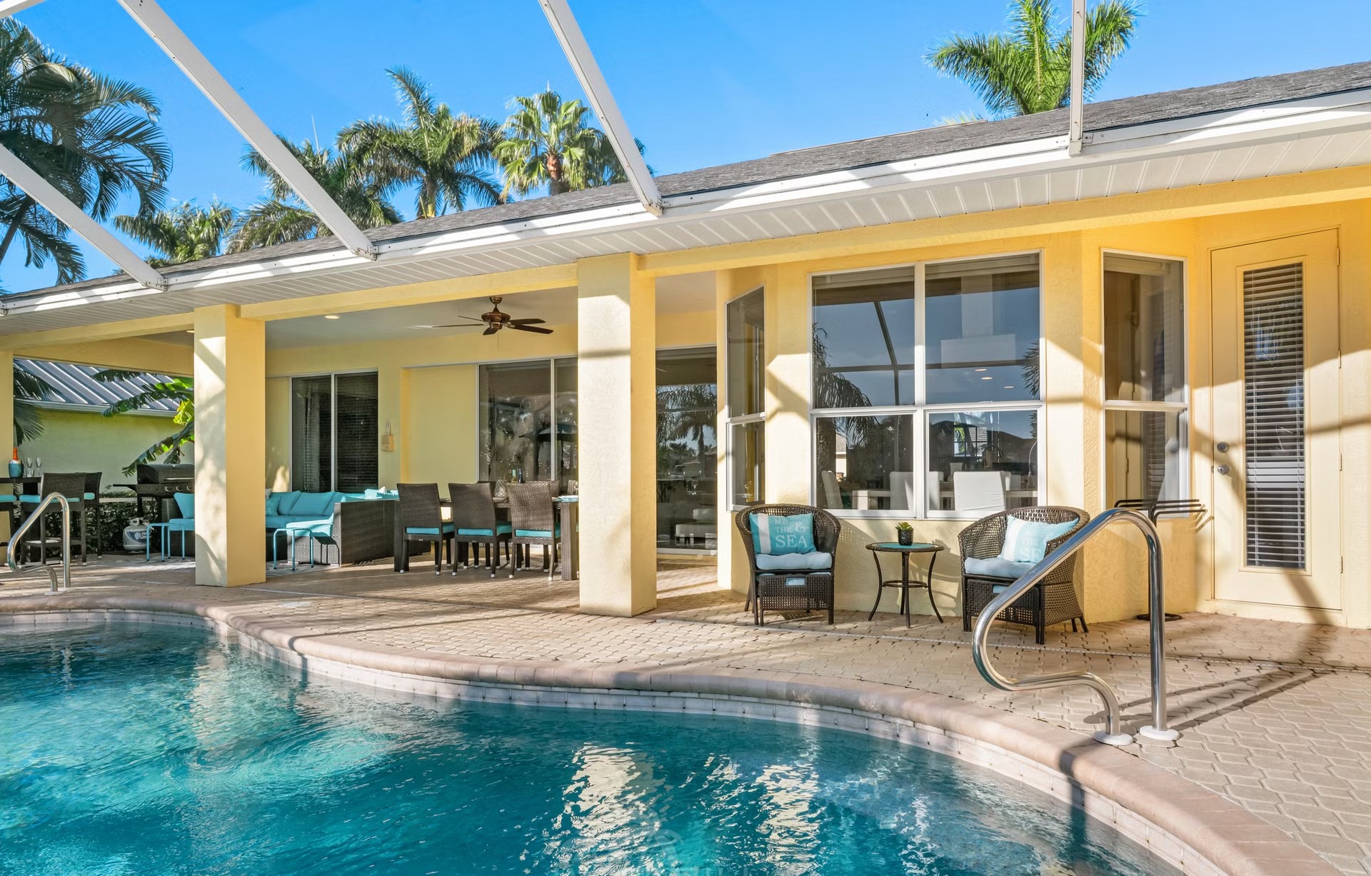 Poolbereich mit Liegen und Blick auf den Kanal am privaten Dock.
