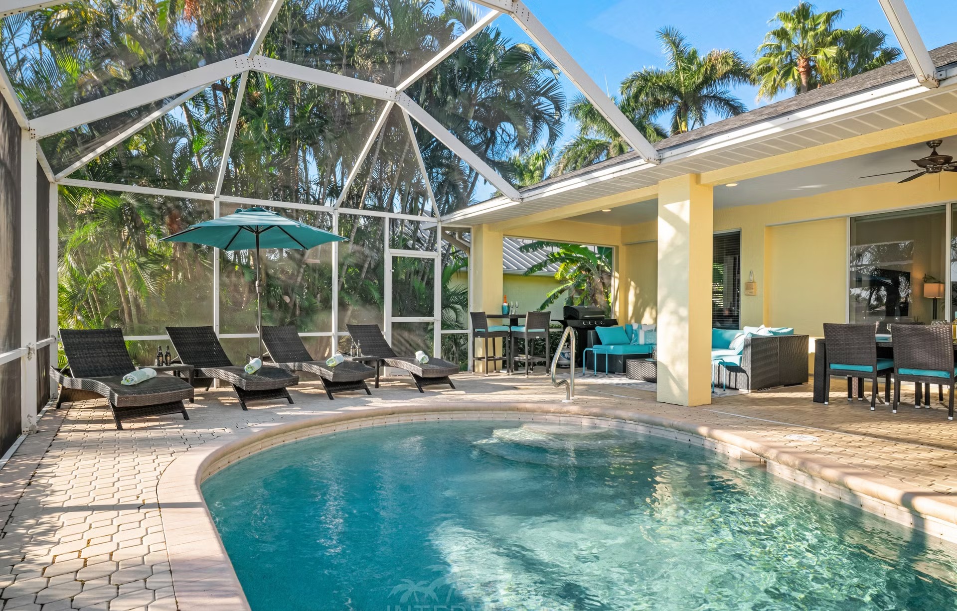 Poolbereich mit Liegen und überdachtem Sitzplatz am Kanal mit Bootssteg und Kajaks.