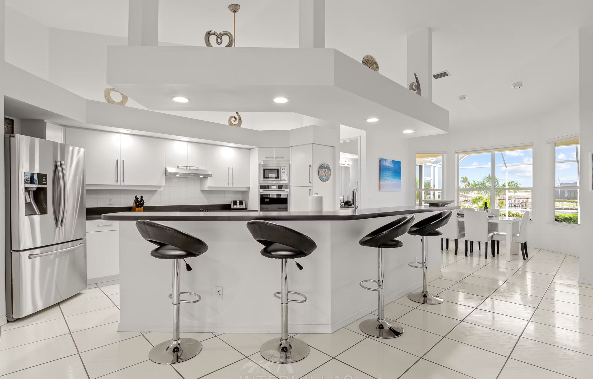 Poolbereich mit Liegen und überdachtem Sitzplatz am Kanal mit Bootssteg und Kajaks.