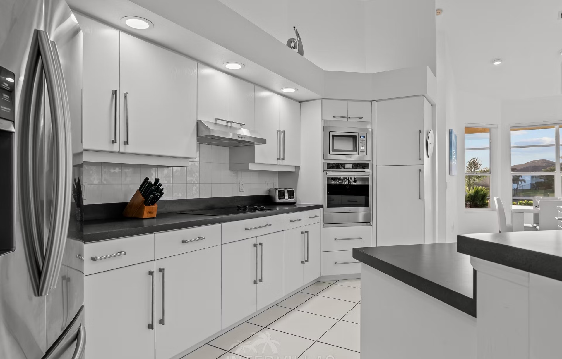 Poolbereich mit Liegen und überdachtem Sitzplatz am Kanal mit Bootssteg.