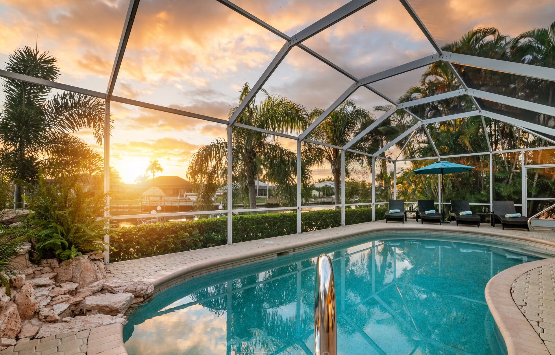 Poolbereich mit Liegen und Blick auf den Kanal am eigenen Dock.