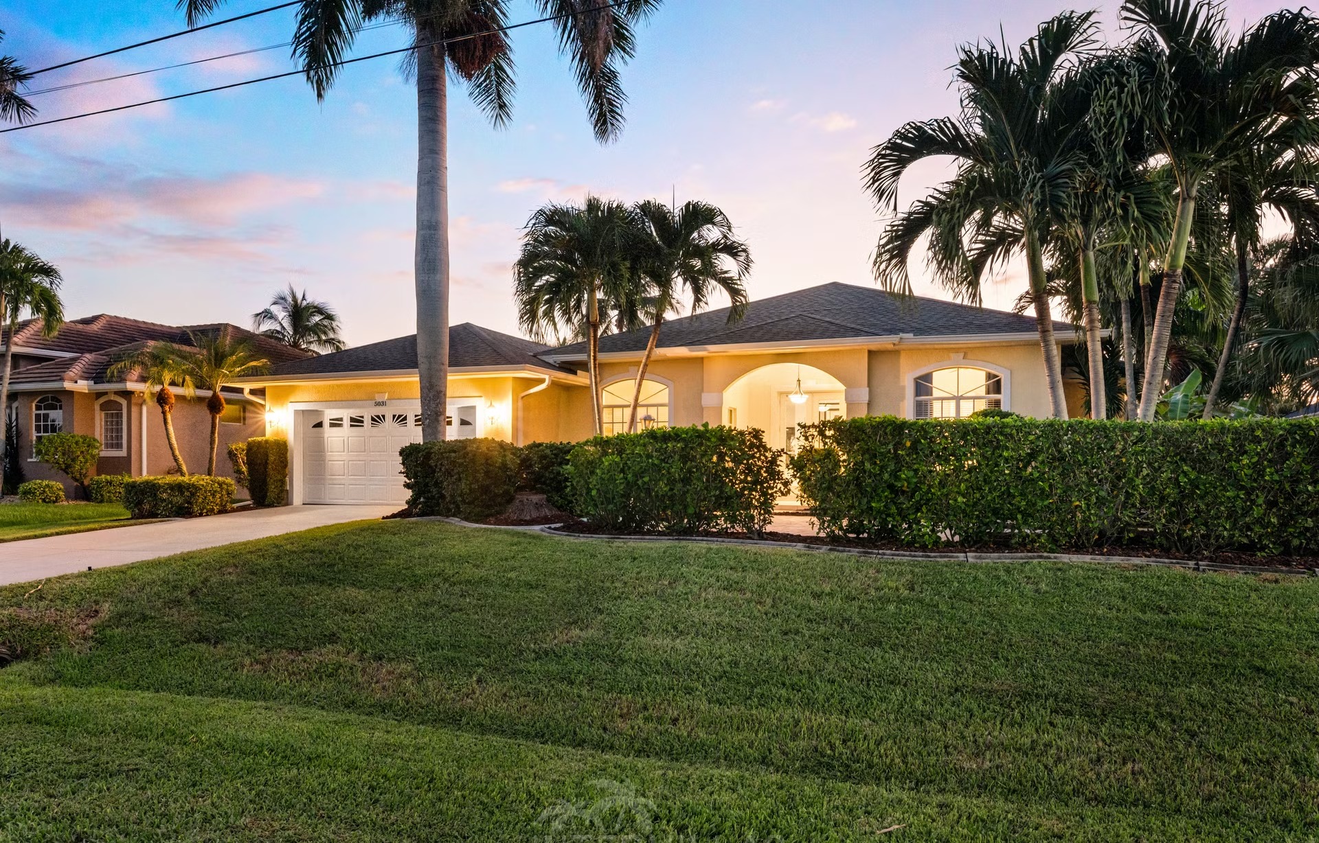 Poolbereich mit Liegen und Blick auf den Kanal am privaten Dock.