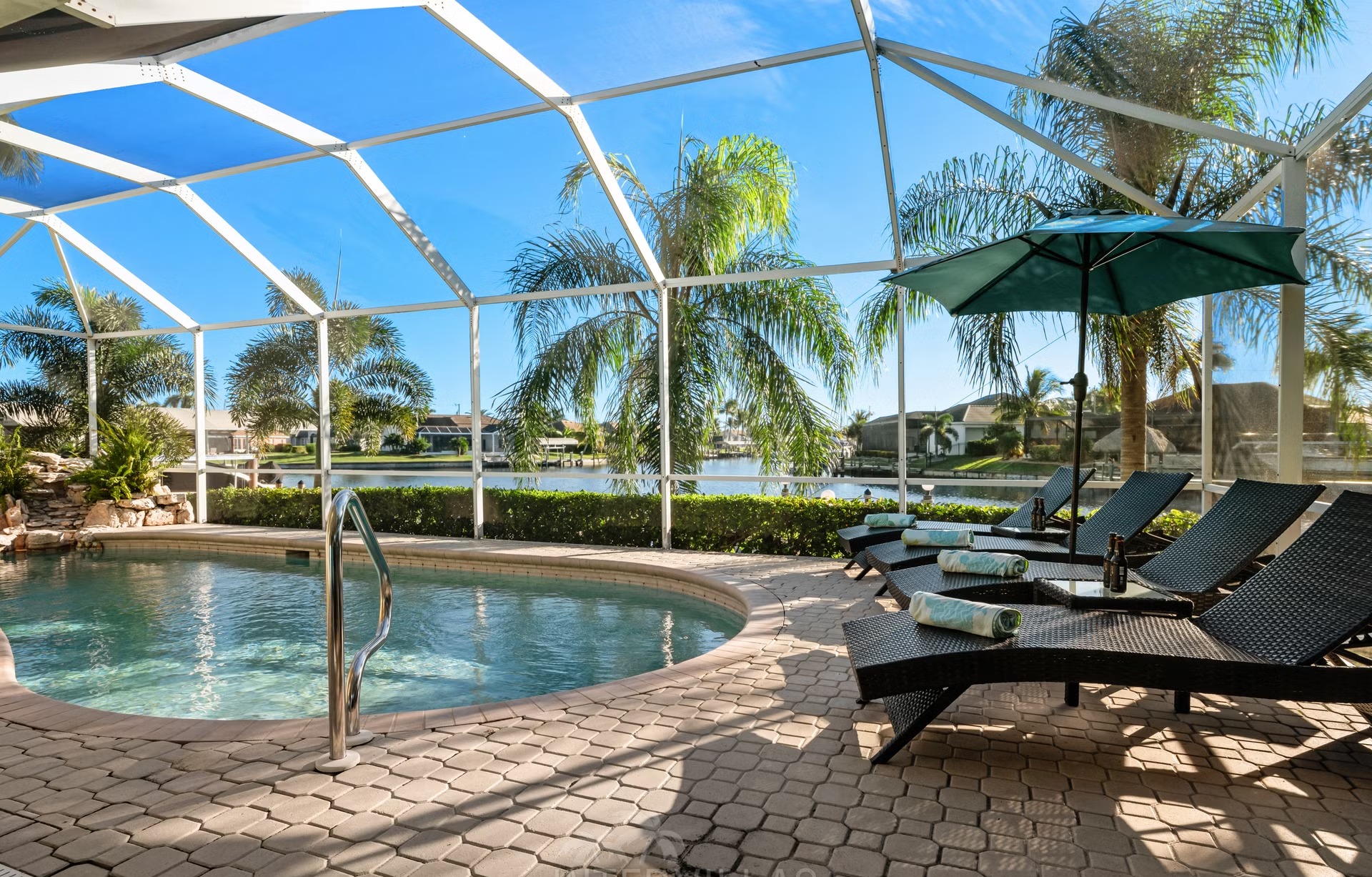 Beheizter Poolbereich mit Liegen und Blick auf den Kanal am eigenen Dock.