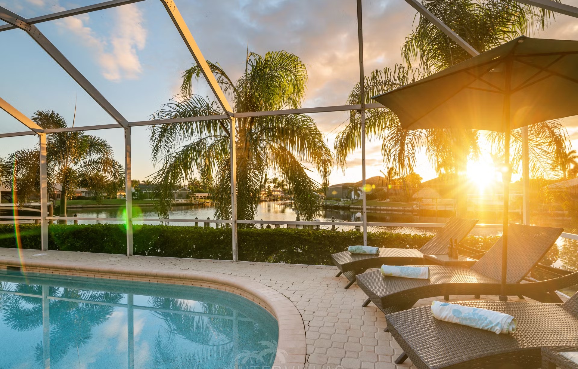 Poolbereich mit Liegen und überdachtem Sitzplatz am Kanal mit Bootsanlegestelle und Kajaks.
