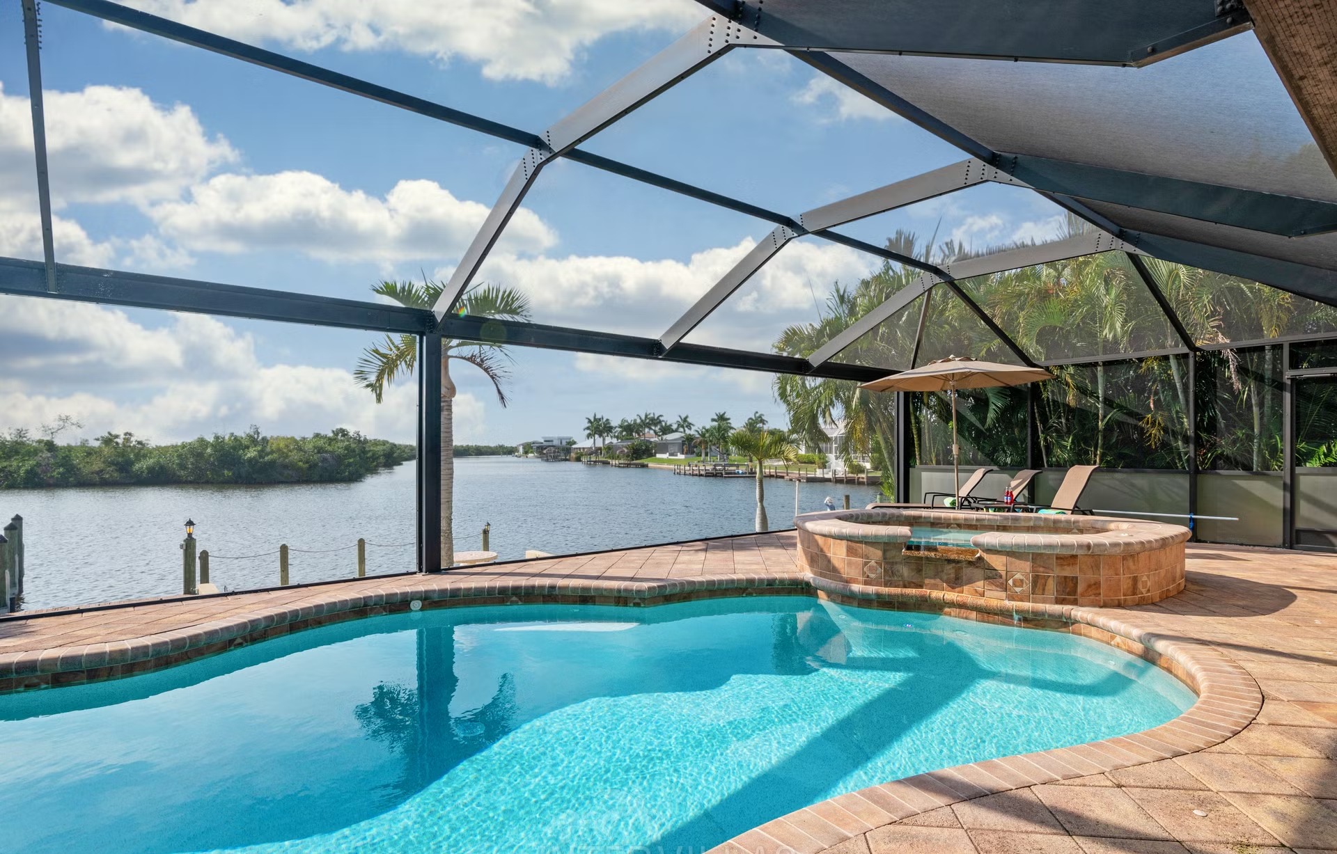 Westlich ausgerichteter Pool mit Spa und Blick auf den Wasserkanal.