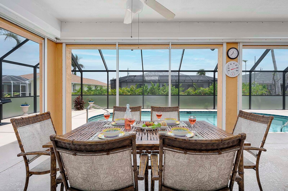 Beheizter Pool mit Lanai und Sitzbereich im Garten.