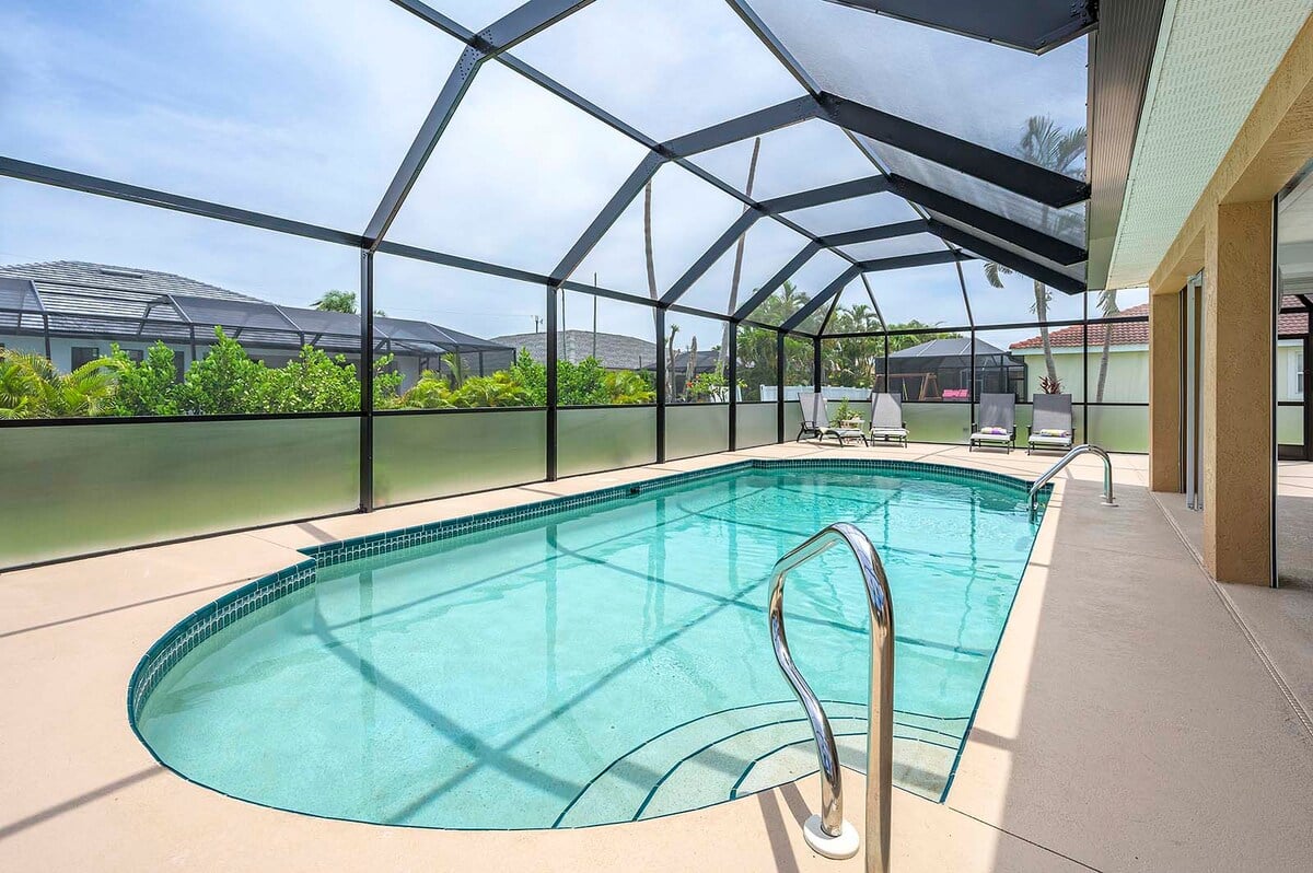 Beheizter Pool mit Lanai und Sitzbereich im Außenbereich.