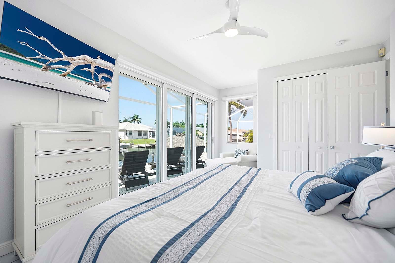 Blick vom zweiten Schlafzimmer mit Kingsize-Bett, viel Licht und Zugang zur Terrasse