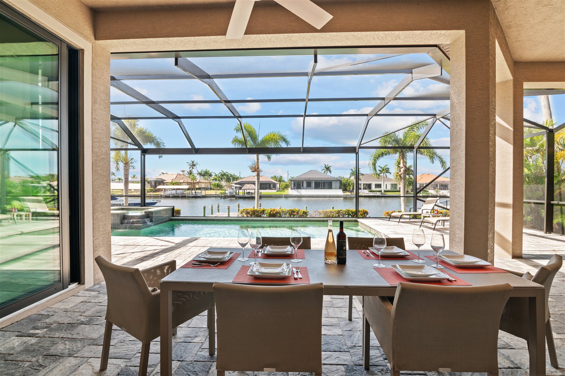 Gedeckter Esstisch auf der Terrasse mit Poolblick