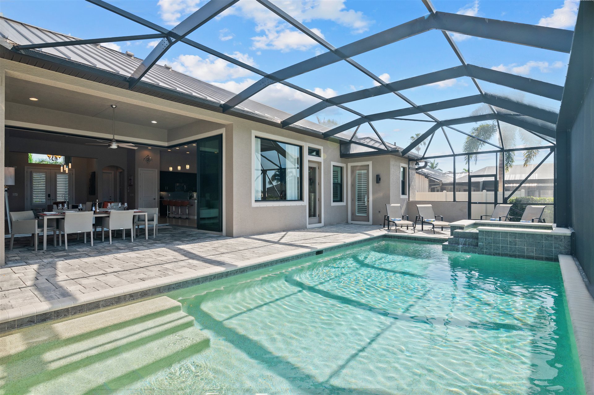 Pool mit Screen-Enclosure und Blick zur Villa
