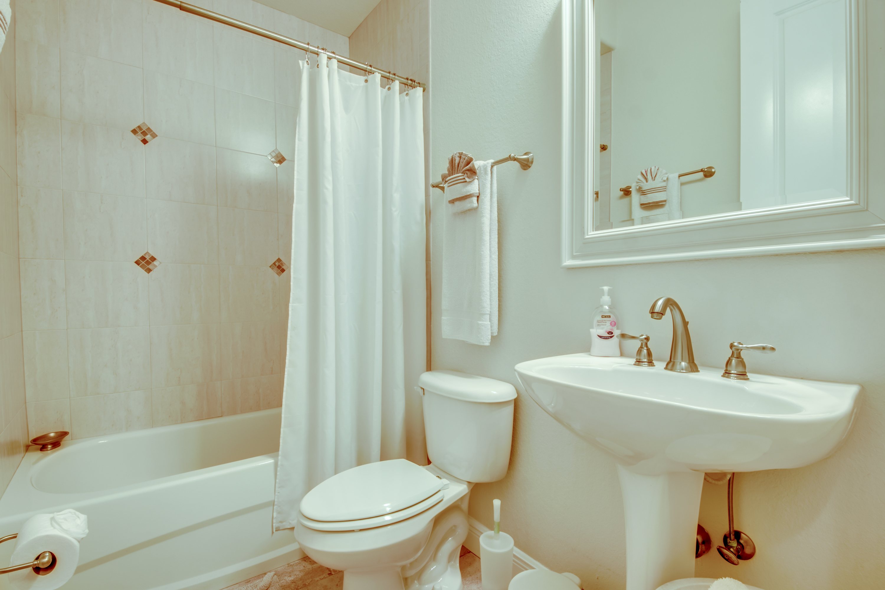 Bad mit Waschbecken, Toilette und Badewanne mit Duschvorhang
